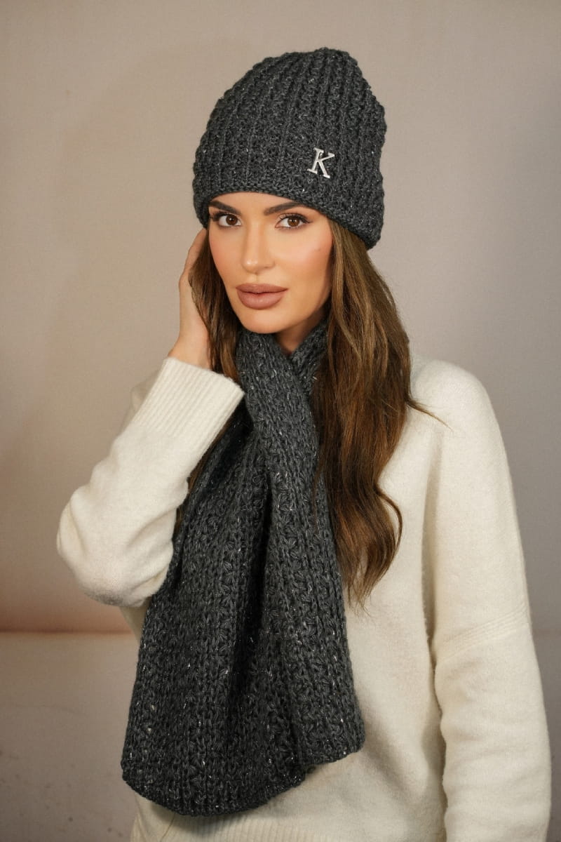 Detal czapki z metalową ozdobą w kształcie litery „K” oraz szalik z praktyczną dziurką do przewlekania | KAMEA | Spironik.pl