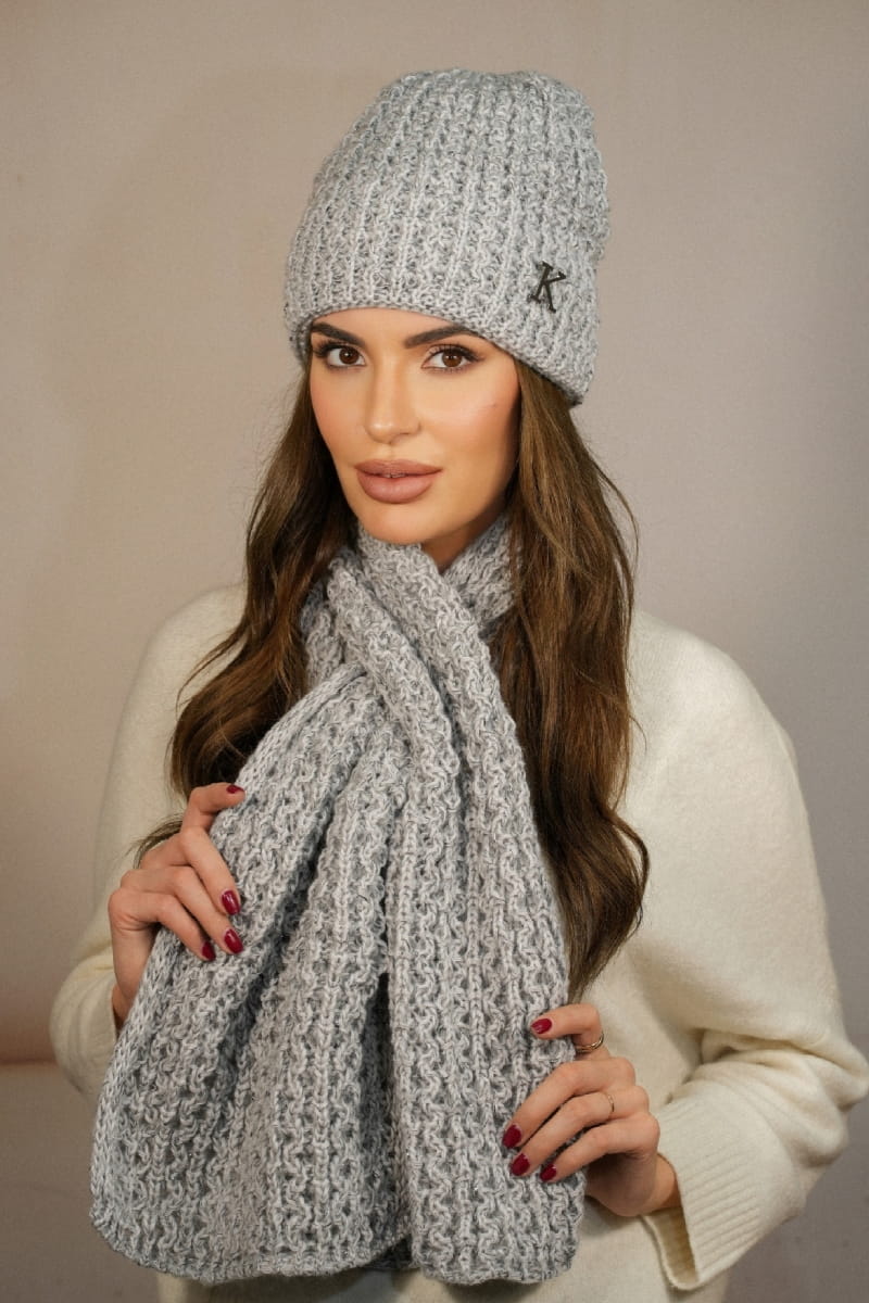 Detal czapki z metalową ozdobą w kształcie litery „K” oraz szalik z praktyczną dziurką do przewlekania | KAMEA | Spironik.pl