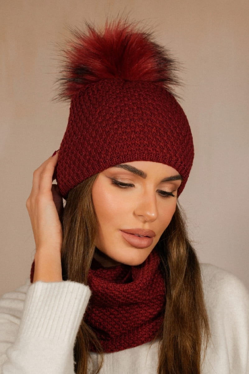 Detal czapki RUBBI z puszystym pomponem i grubym splotem, w zestawie z kominem w bordowym kolorze | KAMEA | Spironik.pl