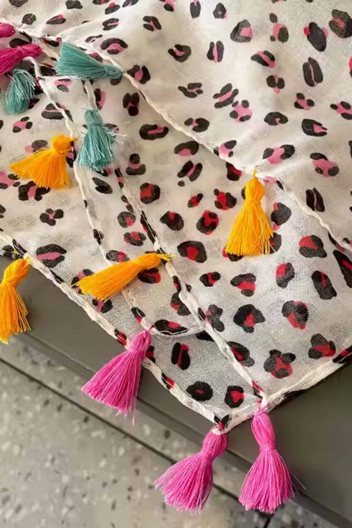 Detal frędzli w kontrastowych kolorach na szalu w stylu panterki, idealny do casualowych stylizacji | KAMEA | Spironik.pl