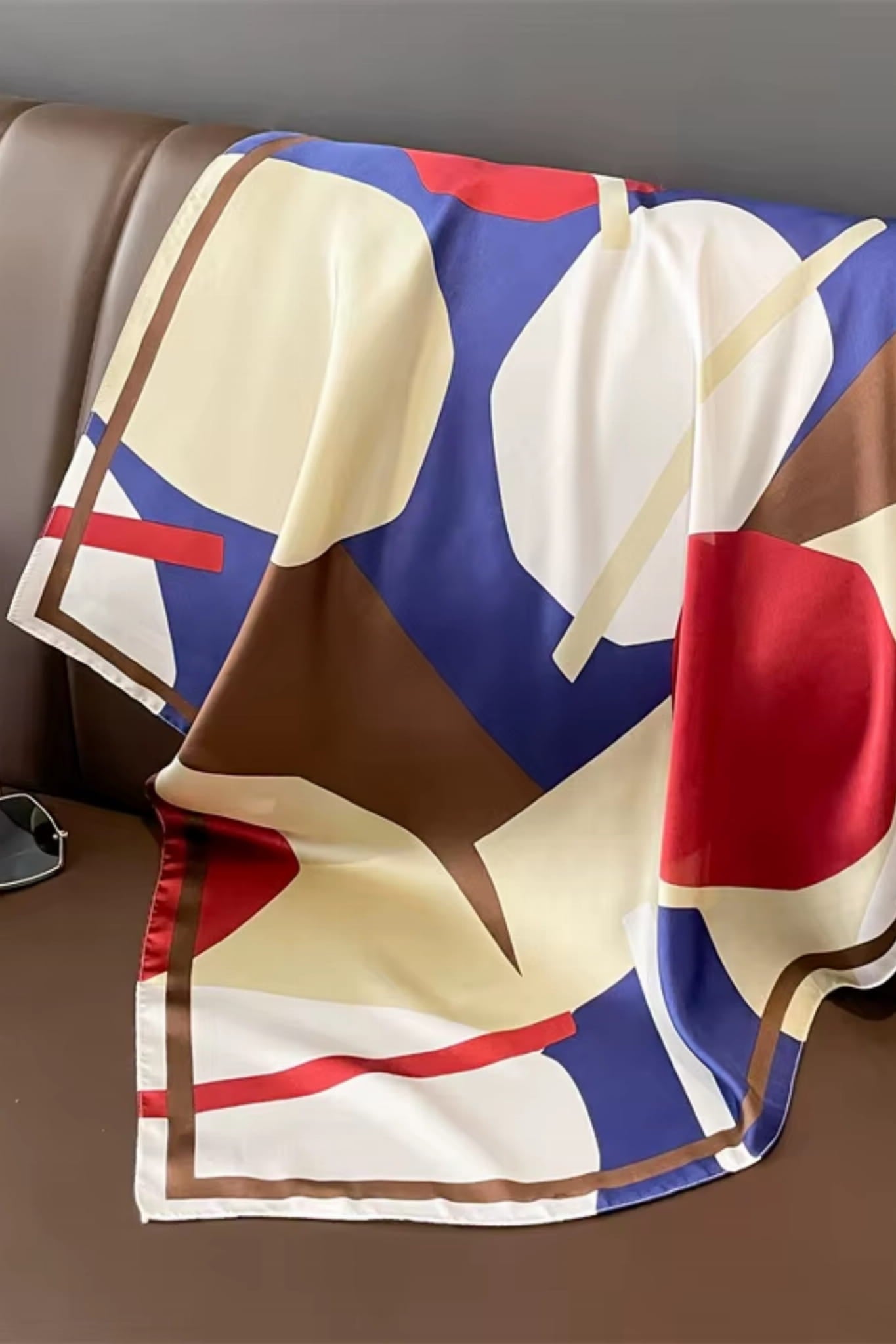 Detal satynowej apaszki z abstrakcyjnym wzorem w kolorach brązowym, kremowym i białym | KAMEA | Spironik.pl