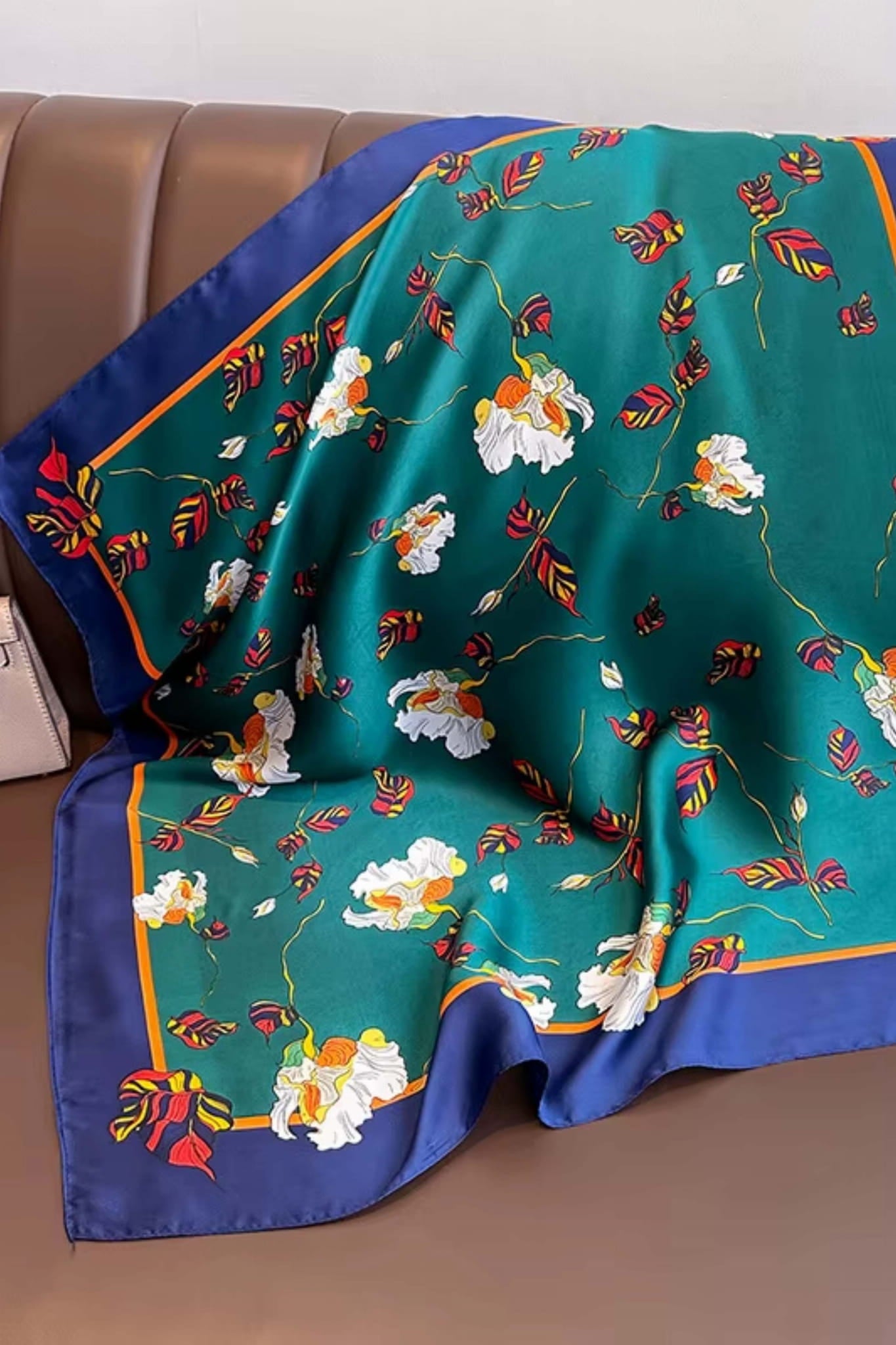 Detal apaszki z roślinnym wzorem w odcieniach bieli, żółci i bordo na tle zieleni | KAMEA | Spironik.pl