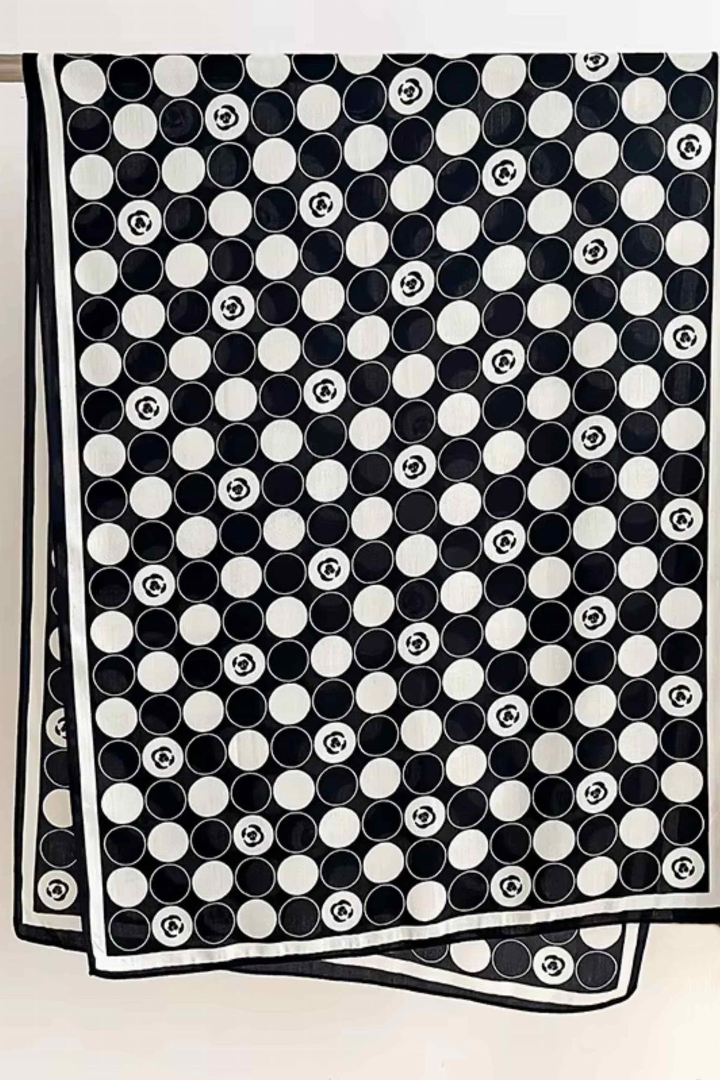 Detal wzoru na czarno-białym szalu w groszki z subtelnym kwiatowym akcentem | KAMEA | Spironik.pl