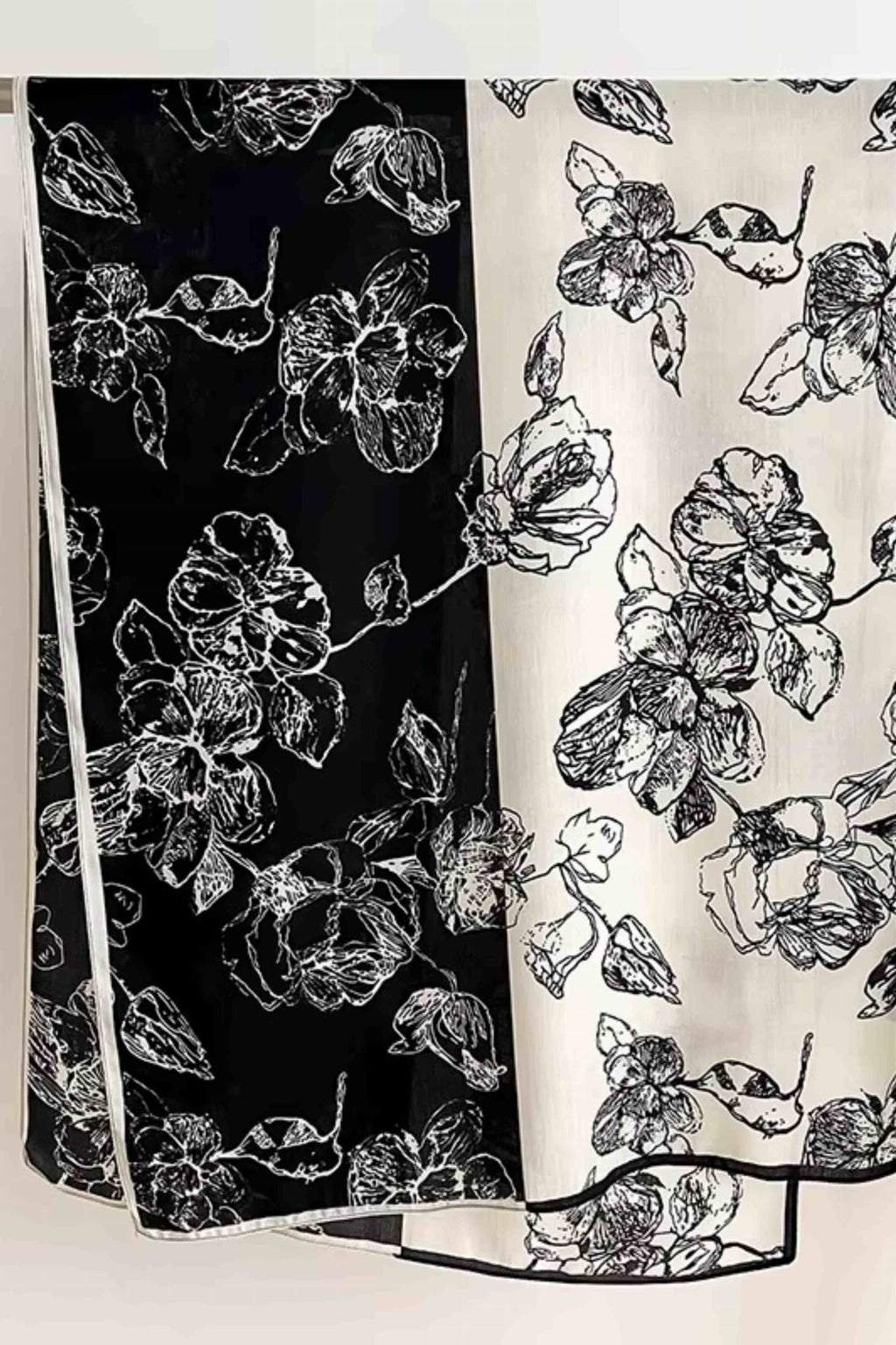 Detail šálu s kresleným vzorem květin v barvách černé a ekru, ideální pro různé stylizace | KAMEA | Spironik.pl