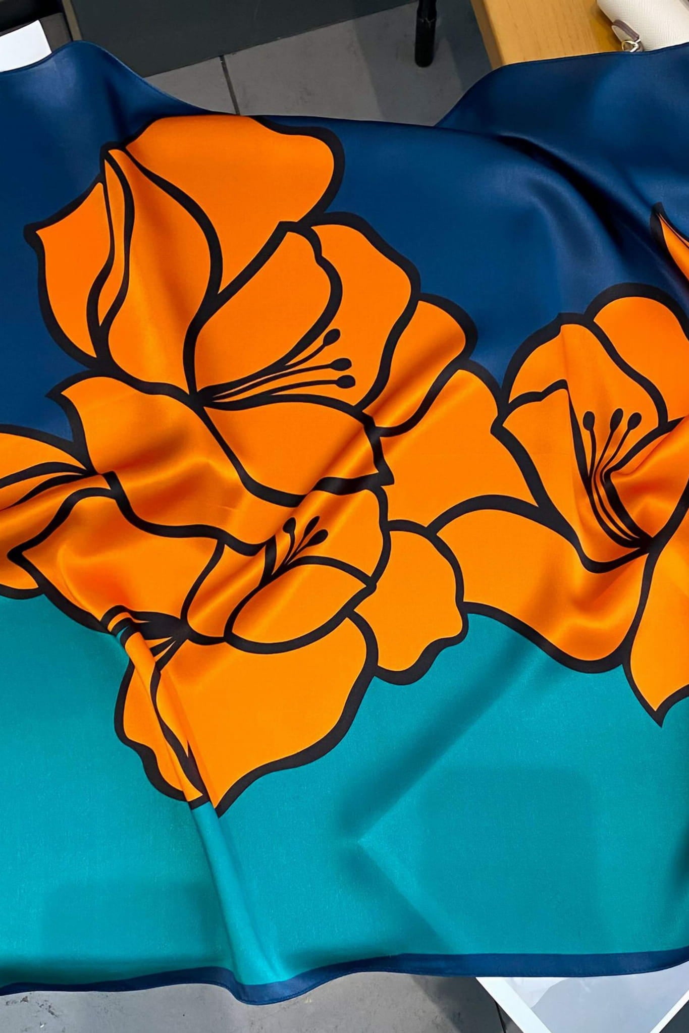 Detal apaszki z graficznym wzorem tropikalnych kwiatów na tle granatowym, wykonana z 100% jedwabiu | KAMEA | Spironik.pl