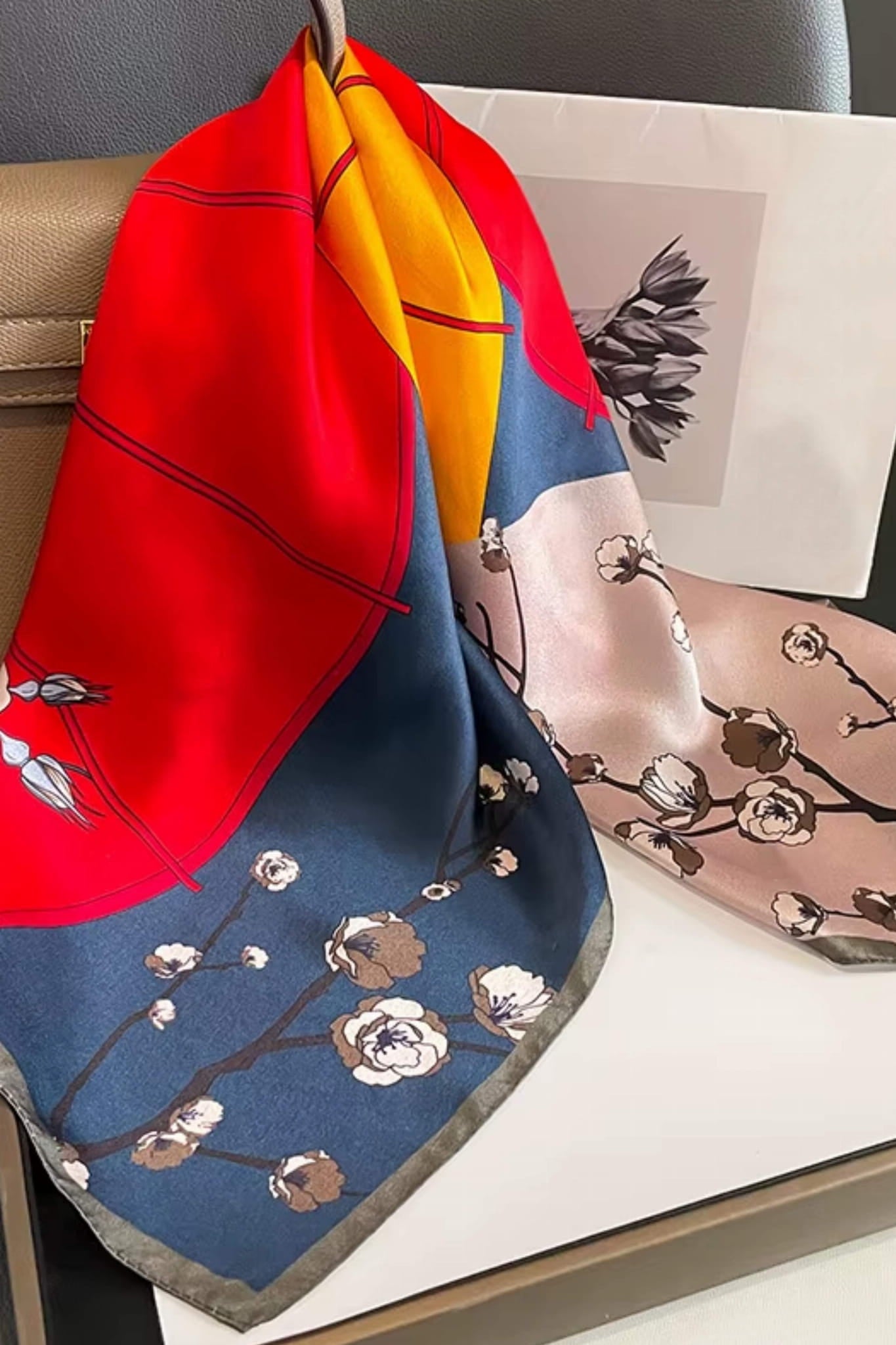 Detal apaszki z jedwabiu, ukazujący motyw kwiatów wiśni i parasoli w intensywnych kolorach | KAMEA | Spironik.pl