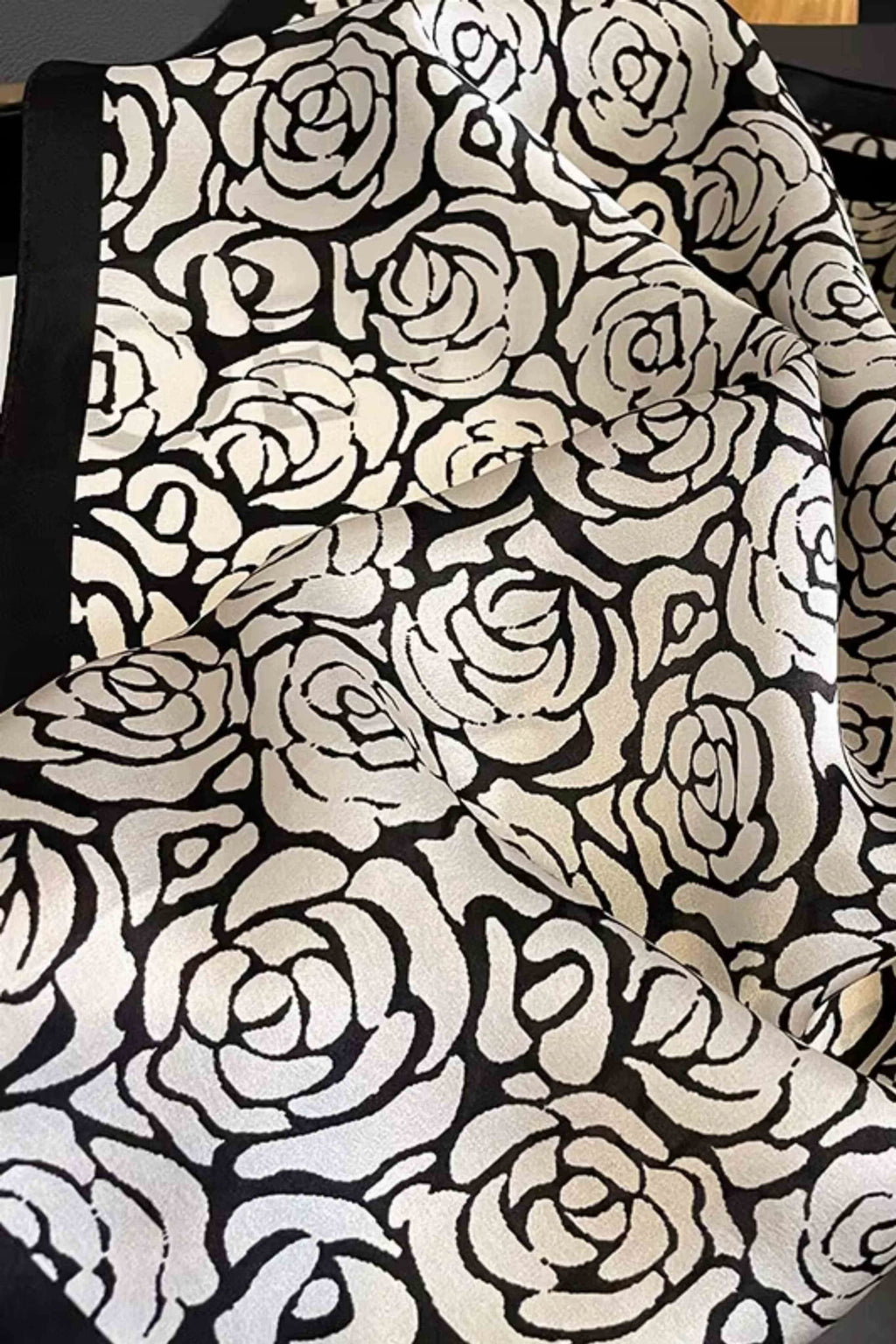 Detal jedwabnej apaszki z widocznym wzorem róż na gładkim, czarnym tle | KAMEA | Spironik.pl