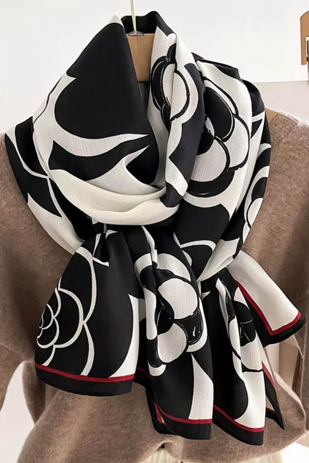 Czarno-biały szal w użyciu, stylowo związany przy szyi, dodający charakteru każdej stylizacji | KAMEA | Spironik.pl