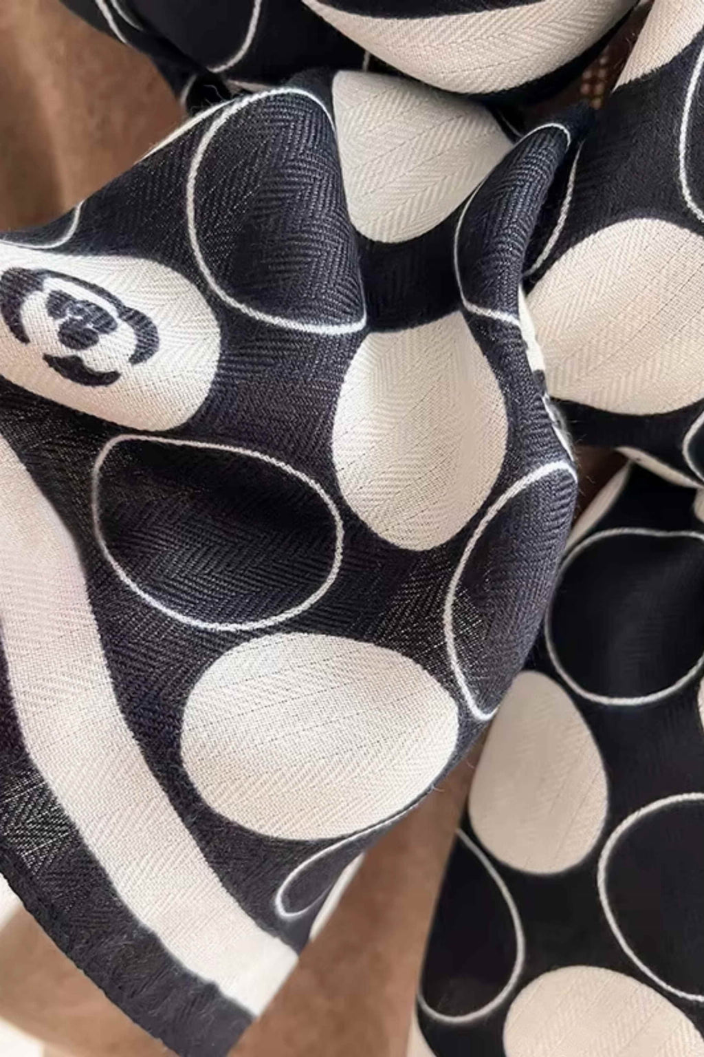 Szal w groszki w użyciu jako stylowy dodatek do eleganckiego płaszcza | KAMEA | Spironik.pl