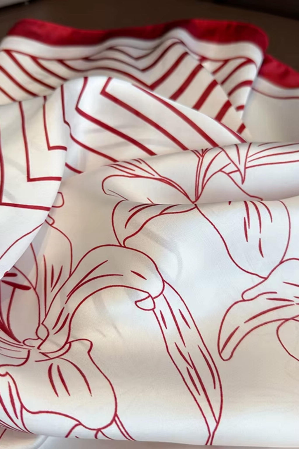 Widok z boku apaszki, prezentujący kontrast między kremowym tłem a czerwonymi liliami | KAMEA | Spironik.pl