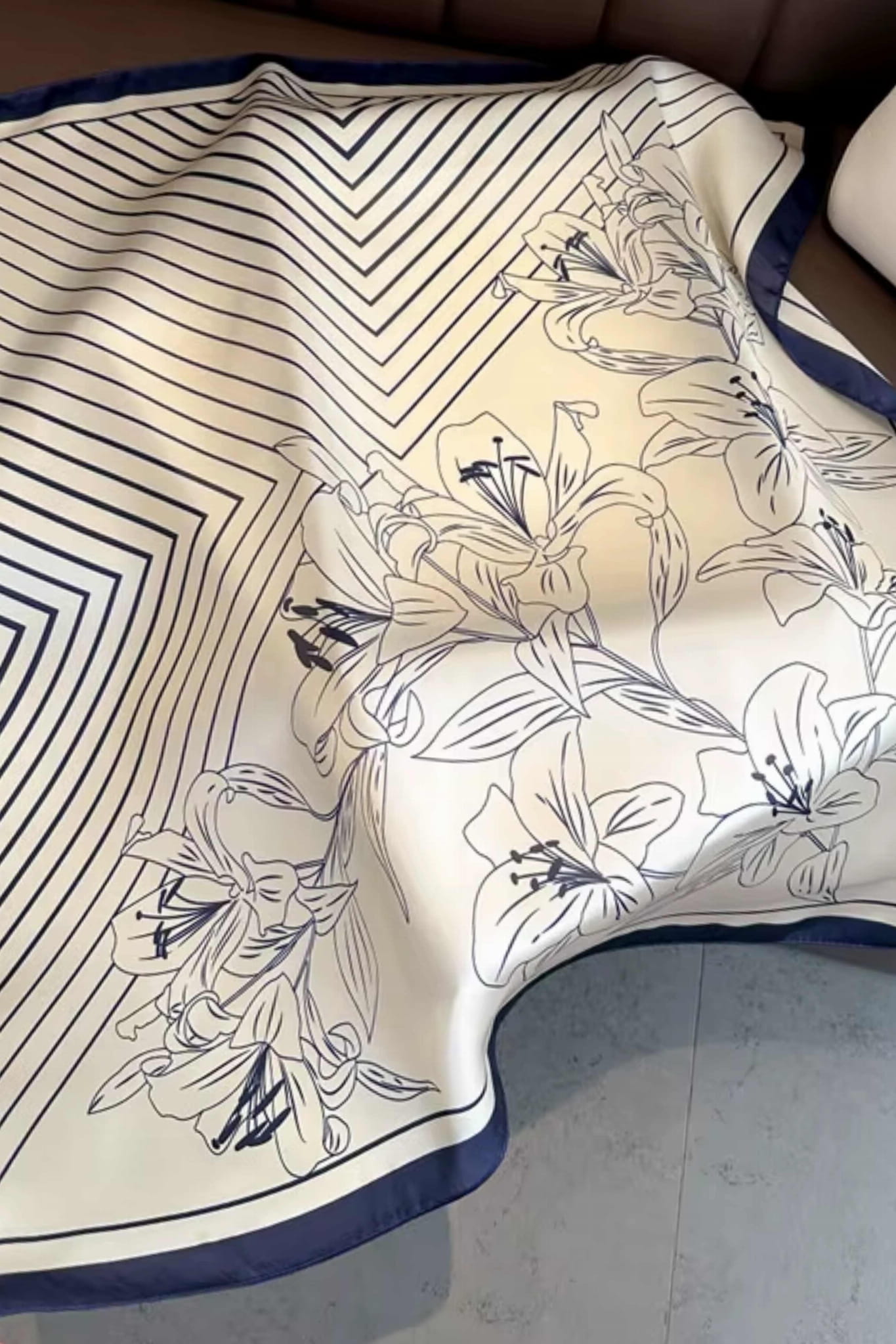 Detal apaszki z ręcznie rysowanymi liliami na tle w odcieniu ciepłej bieli | KAMEA | Spironik.pl