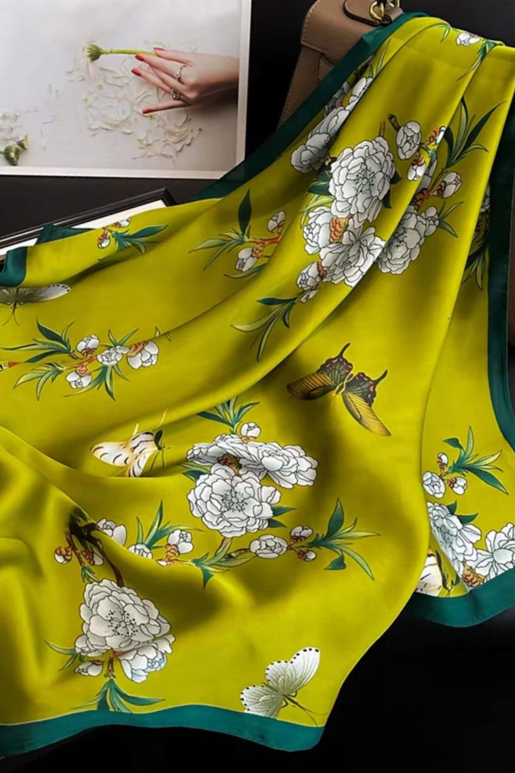 Detal satynowej apaszki z piwoniami i motylami na tle intensywnej zieleni, idealna na wiosenne stylizacje | KAMEA | Spironik.pl