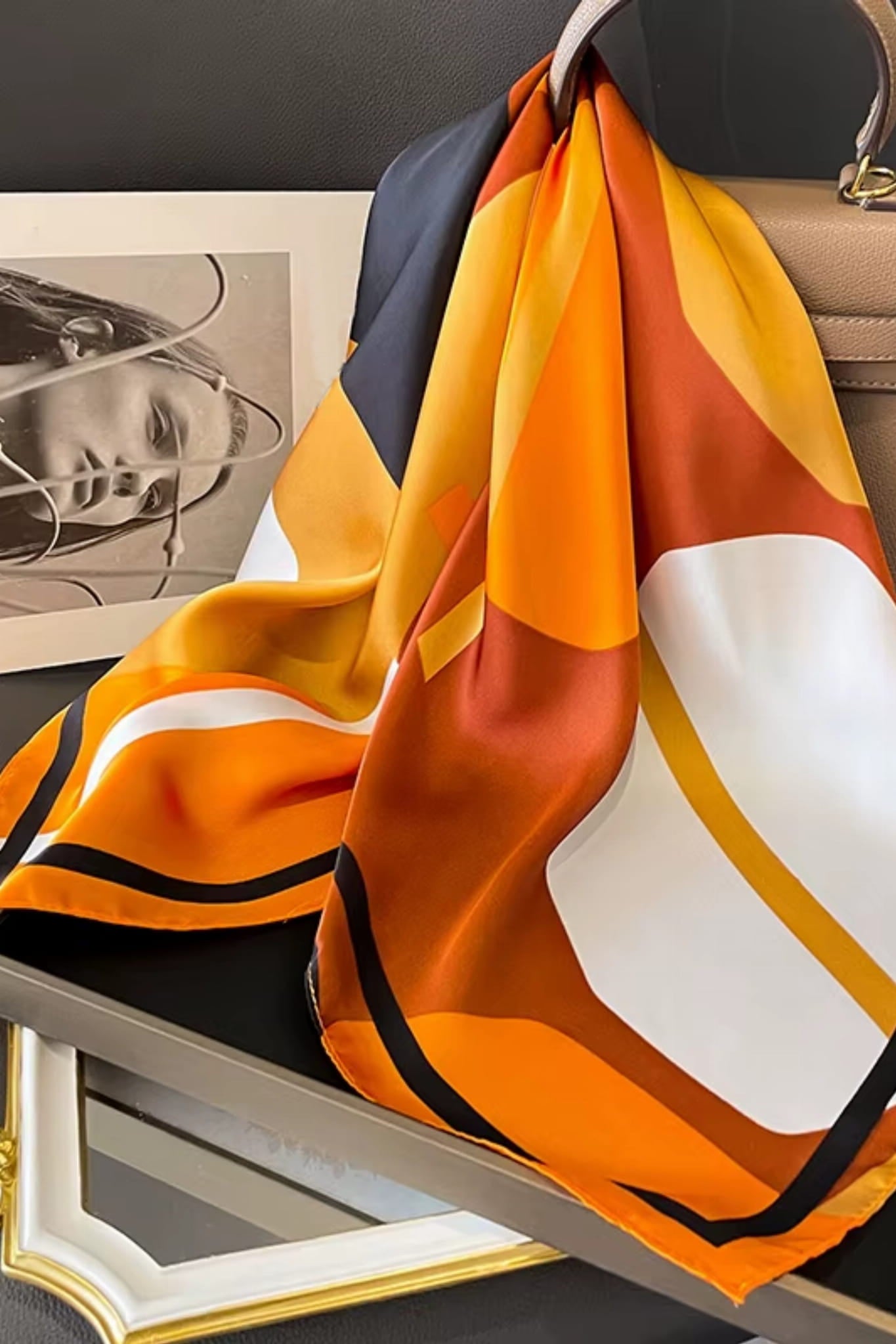 Detal satynowej apaszki z abstrakcyjnym wzorem w kolorach bursztynu, czerni i bieli | KAMEA | Spironik.pl