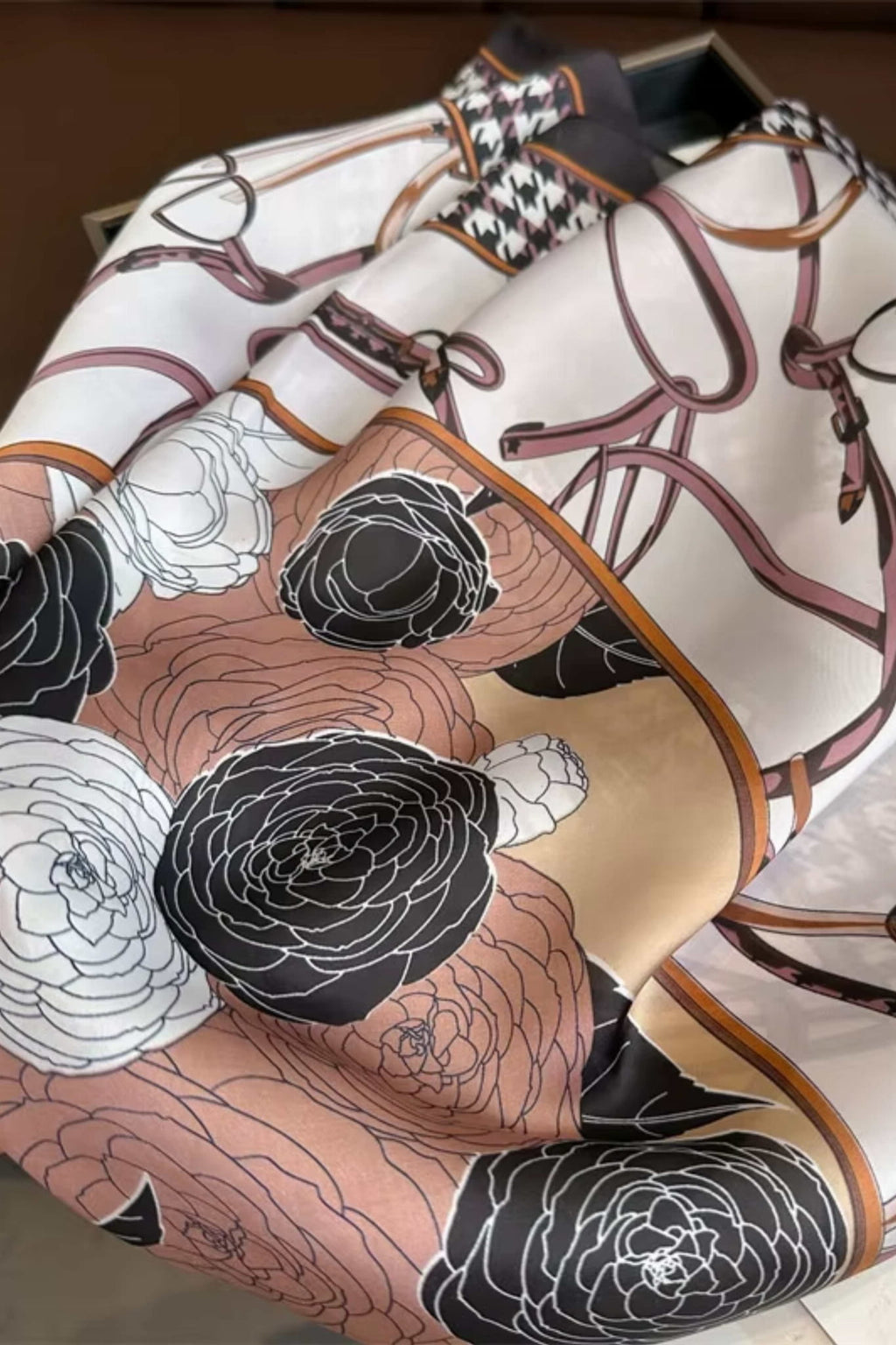 Apaszka damska w użyciu, stylizowana na szyi, z eleganckim wzorem kwiatowym i bordiurą pepitki | KAMEA | Spironik.pl