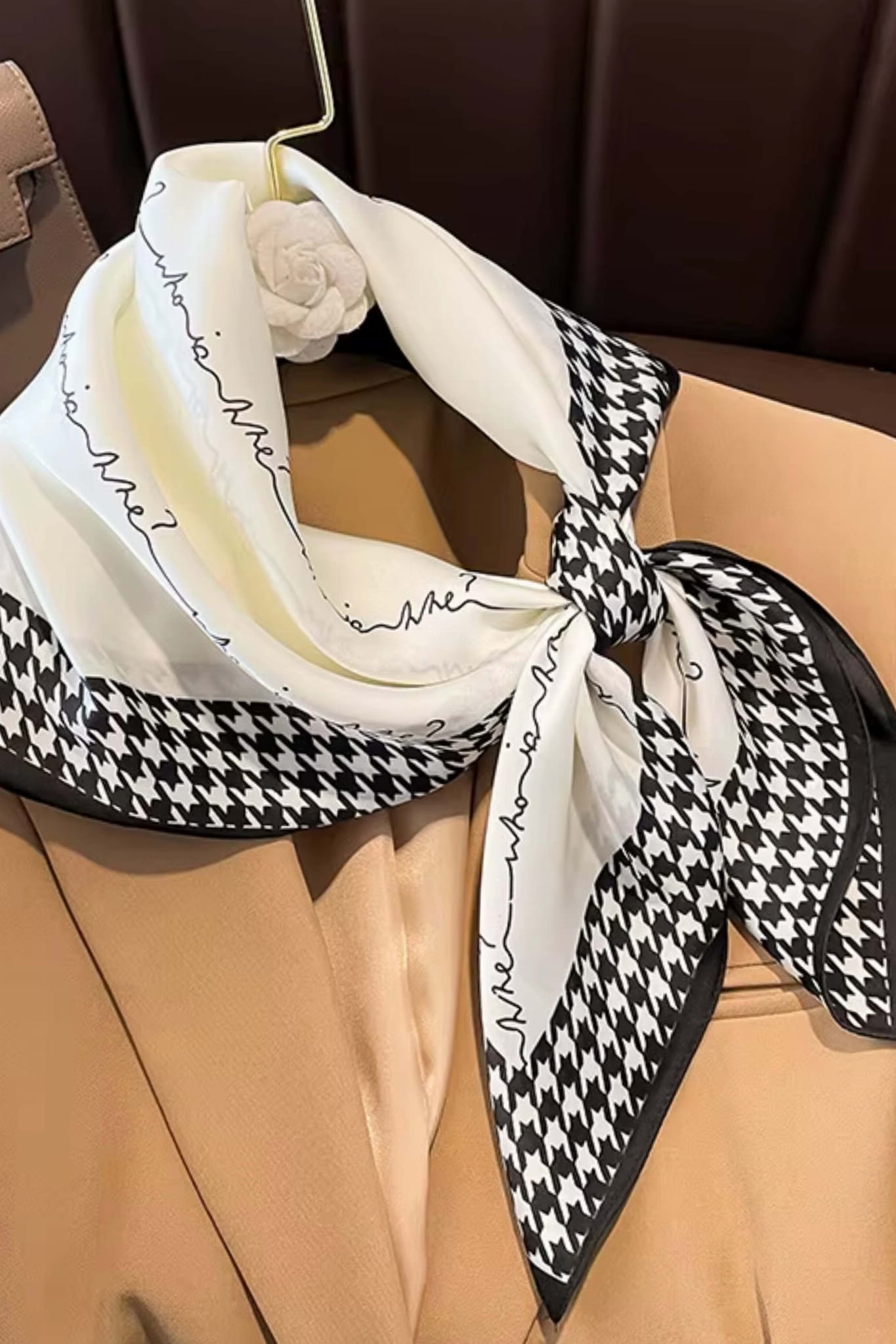 Boczny widok na apaszkę z pepitką, wykonana z materiału przypominającego jedwab, w kolorach kremowym i czarnym | KAMEA | Spironik.pl