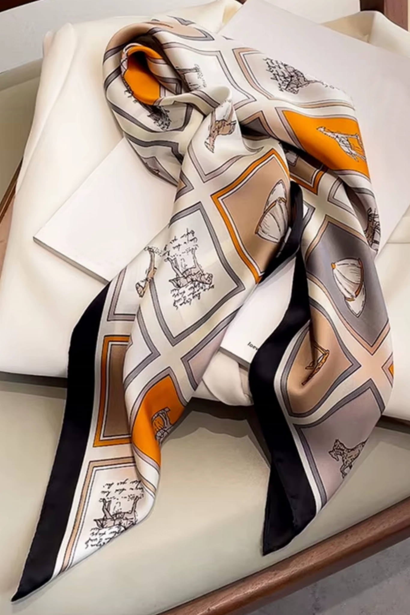 Widok apaszki z akcentami pomarańczu, podkreślający elegancję klasycznego jeździectwa | KAMEA | Spironik.pl