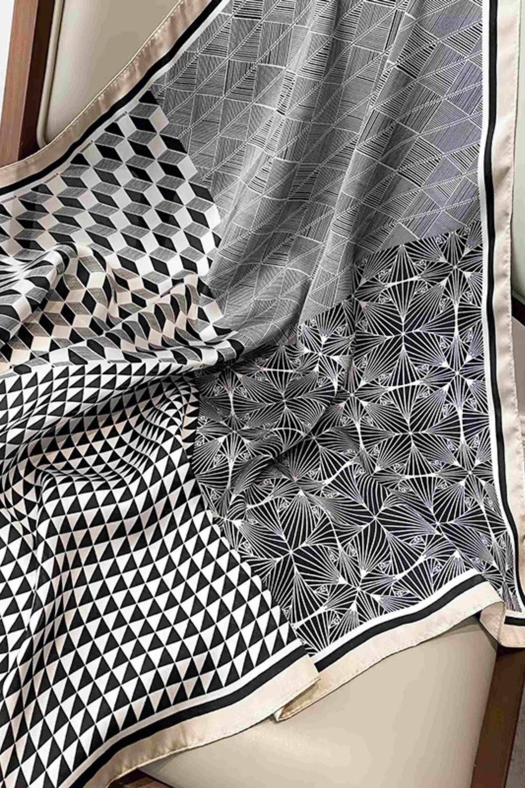 Detal satynowej apaszki o wymiarach 70x70 cm, ukazujący geometryczny motyw w kolorach czerni i beżu | KAMEA | Spironik.pl