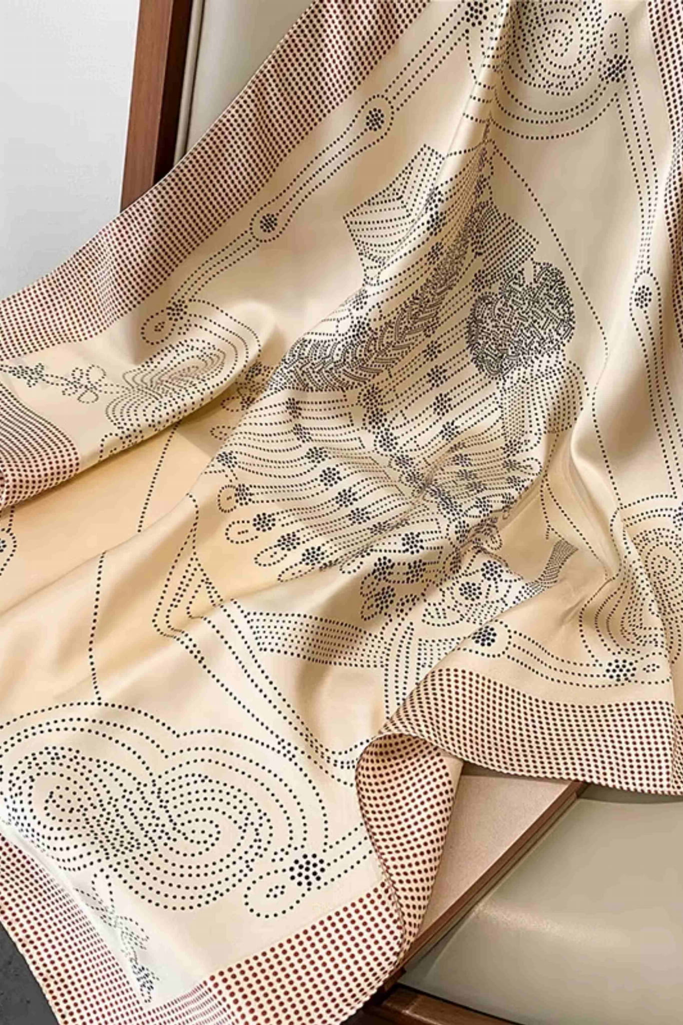 Detal satynowej apaszki w kolorze kremowym z czarnym wzorem, imitującej jedwab, o wymiarach 70x70 cm | KAMEA | Spironik.pl