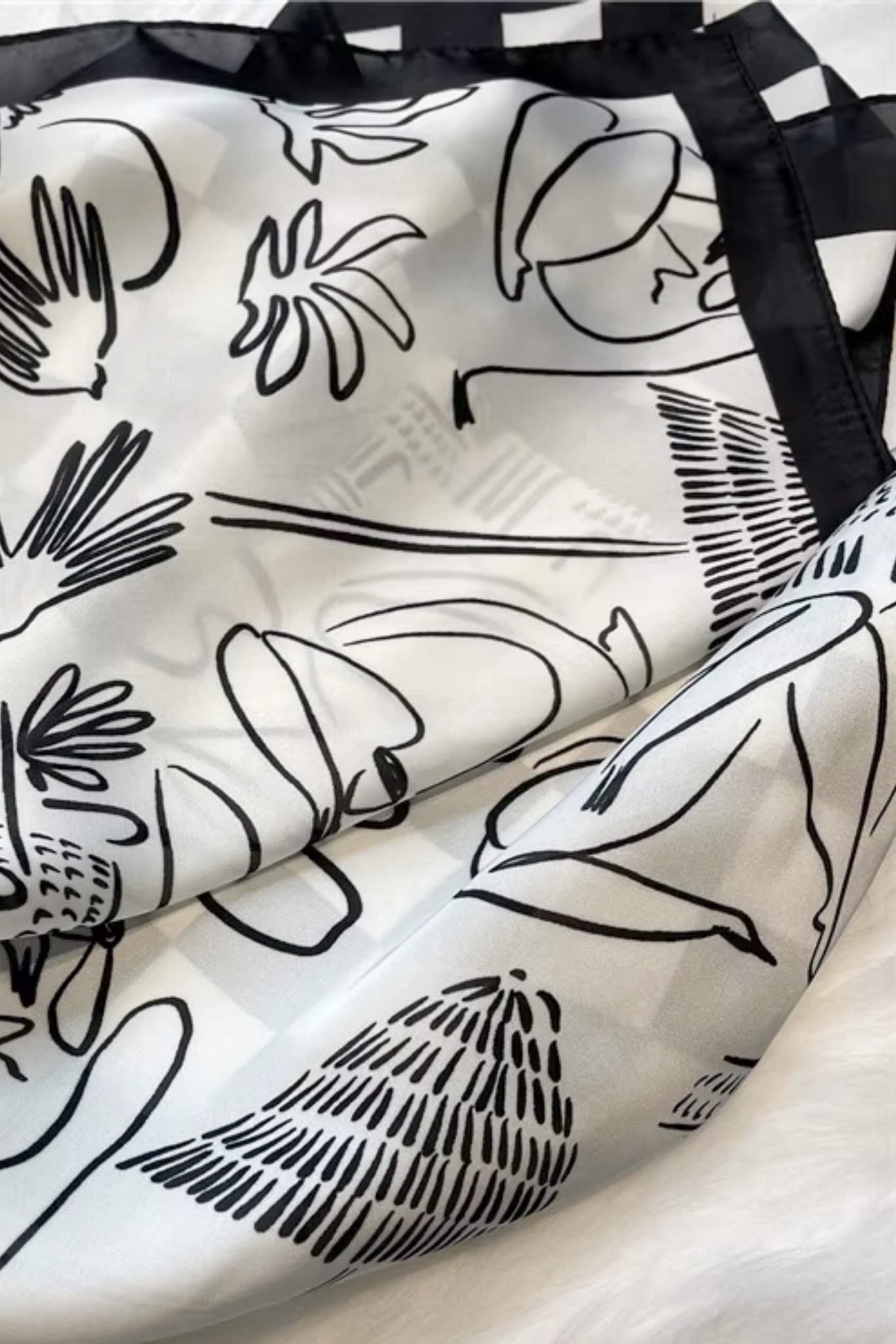 Widok z boku na apaszkę czarno-białą, ukazujący jej delikatny połysk i gładką fakturę | KAMEA | Spironik.pl