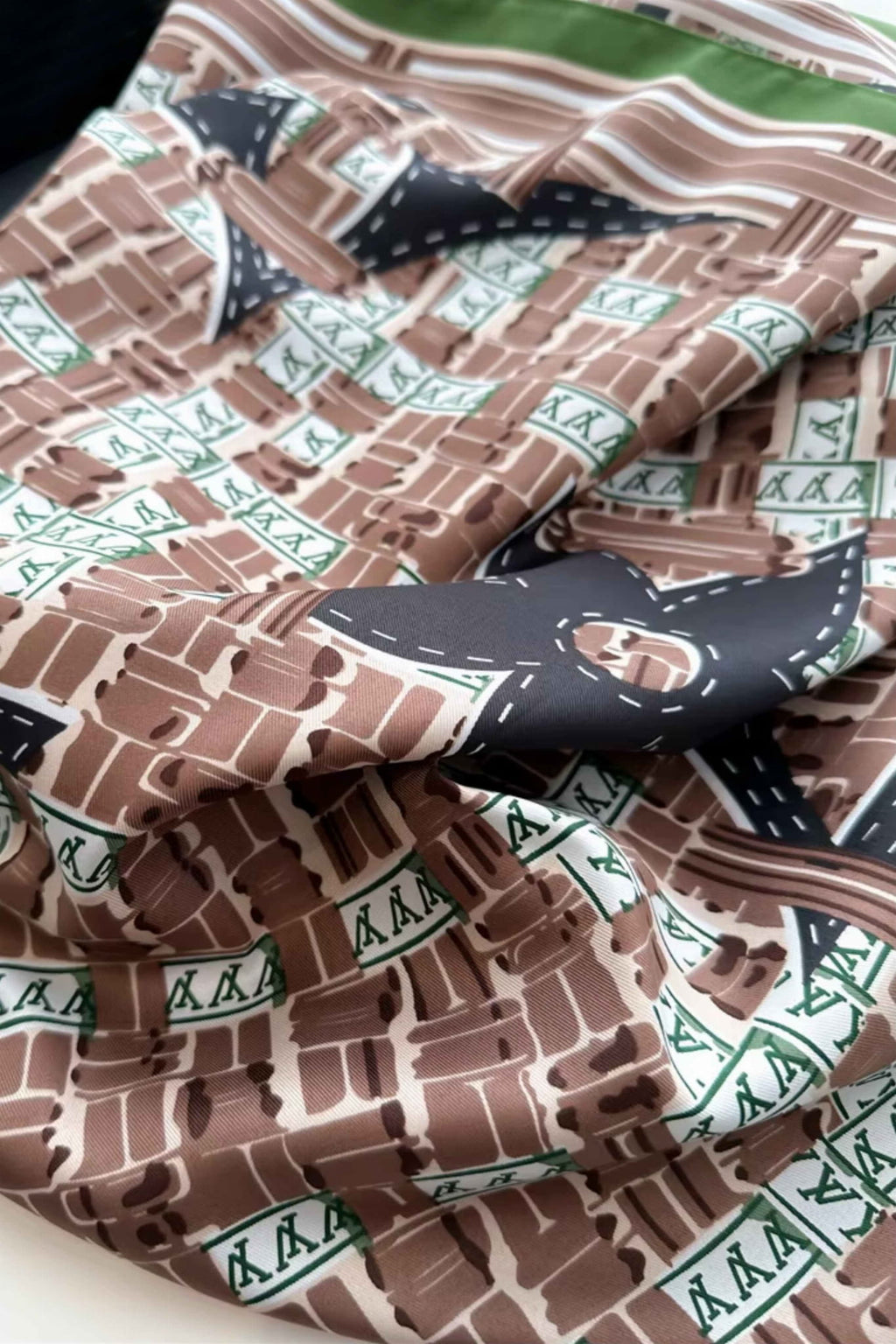 Apaszka 90x90 cm złożona na stole, ukazująca różnorodność kolorów: brąz, zieleń, czerń | KAMEA | Spironik.pl