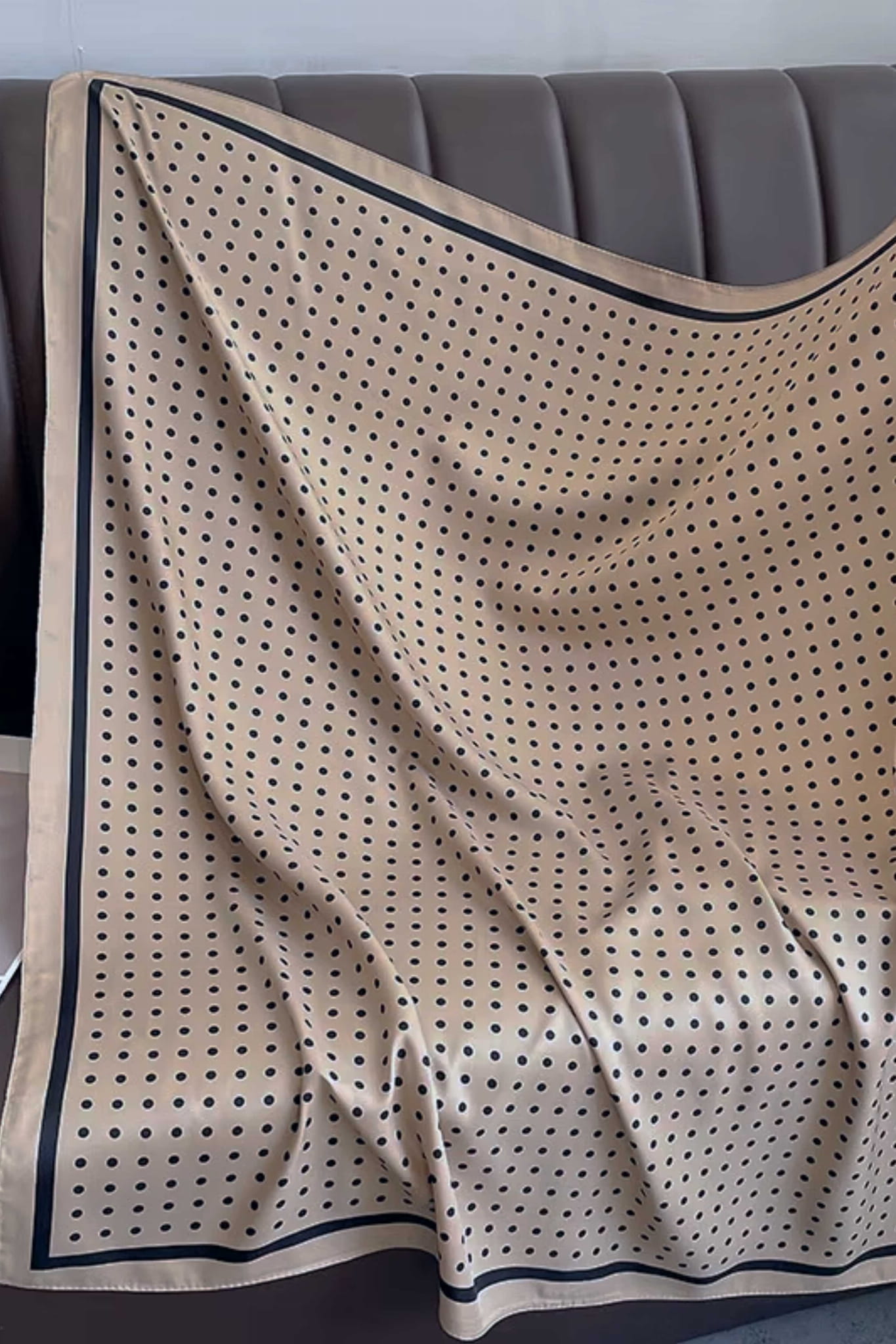 Detal beżowej apaszki z czarnymi groszkami, ukazujący subtelną fakturę materiału | KAMEA | Spironik.pl