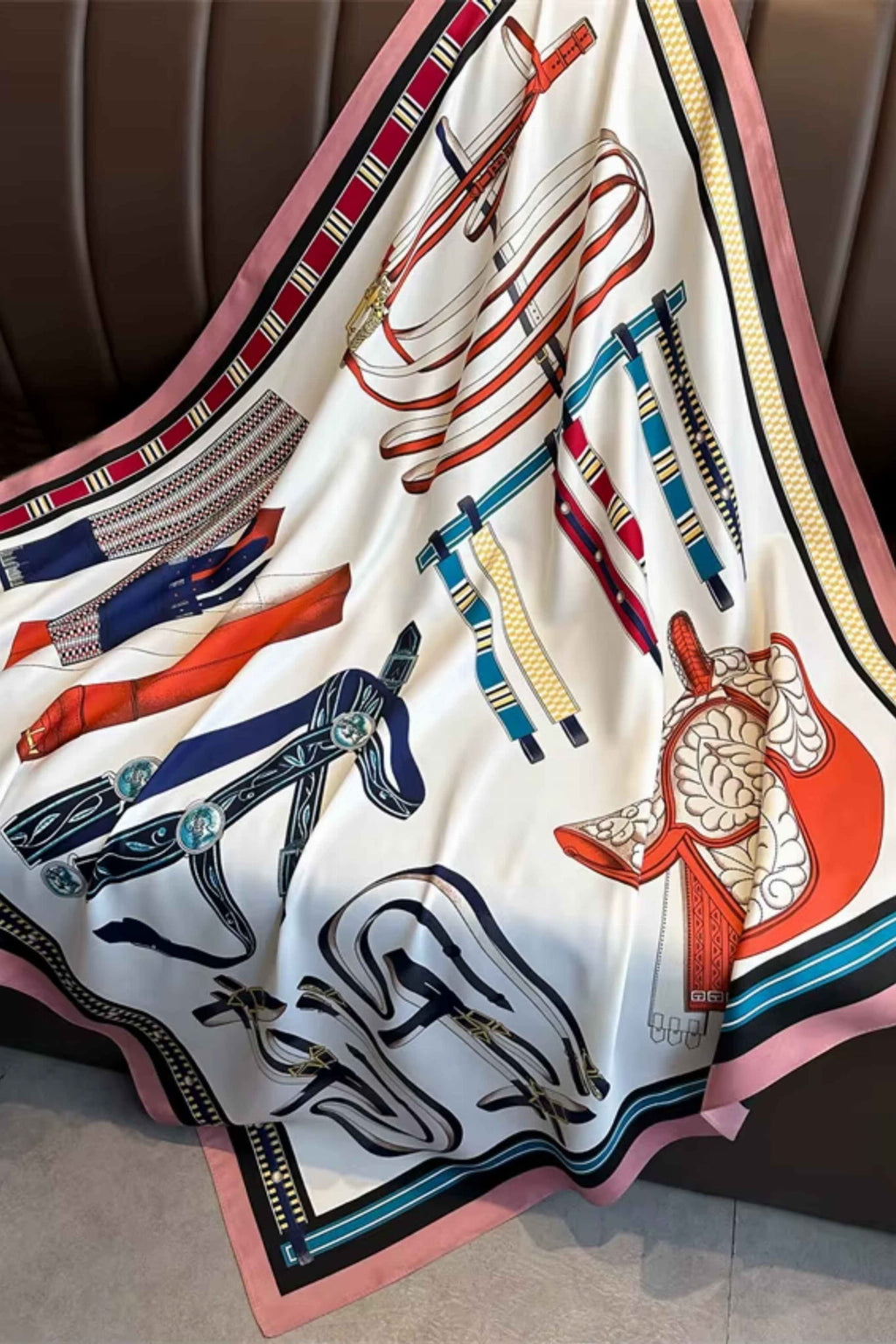 Detal apaszki z motywem jeździeckim, ukazujący elegancką ramkę w odcieniach różu i granatu | KAMEA | Spironik.pl