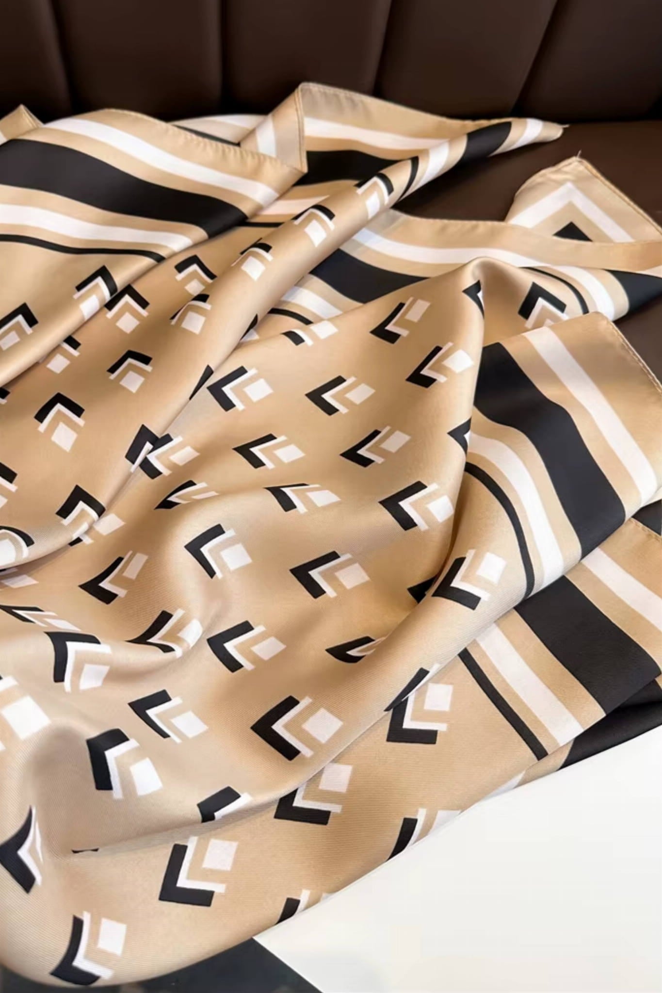 Apaszka w stylu retro, złożona na stole, prezentująca subtelny beżowy kolor i minimalistyczny design | KAMEA | Spironik.pl