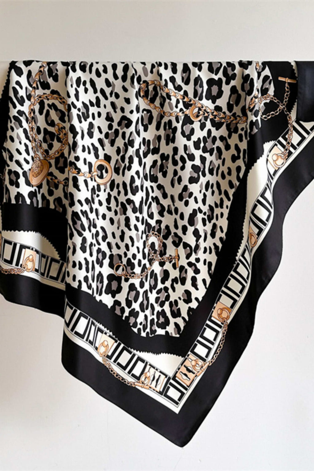 Detal wzoru panterki i złotych łańcuchów na apaszce z satyny, idealnej do eleganckich stylizacji | KAMEA | Spironik.pl