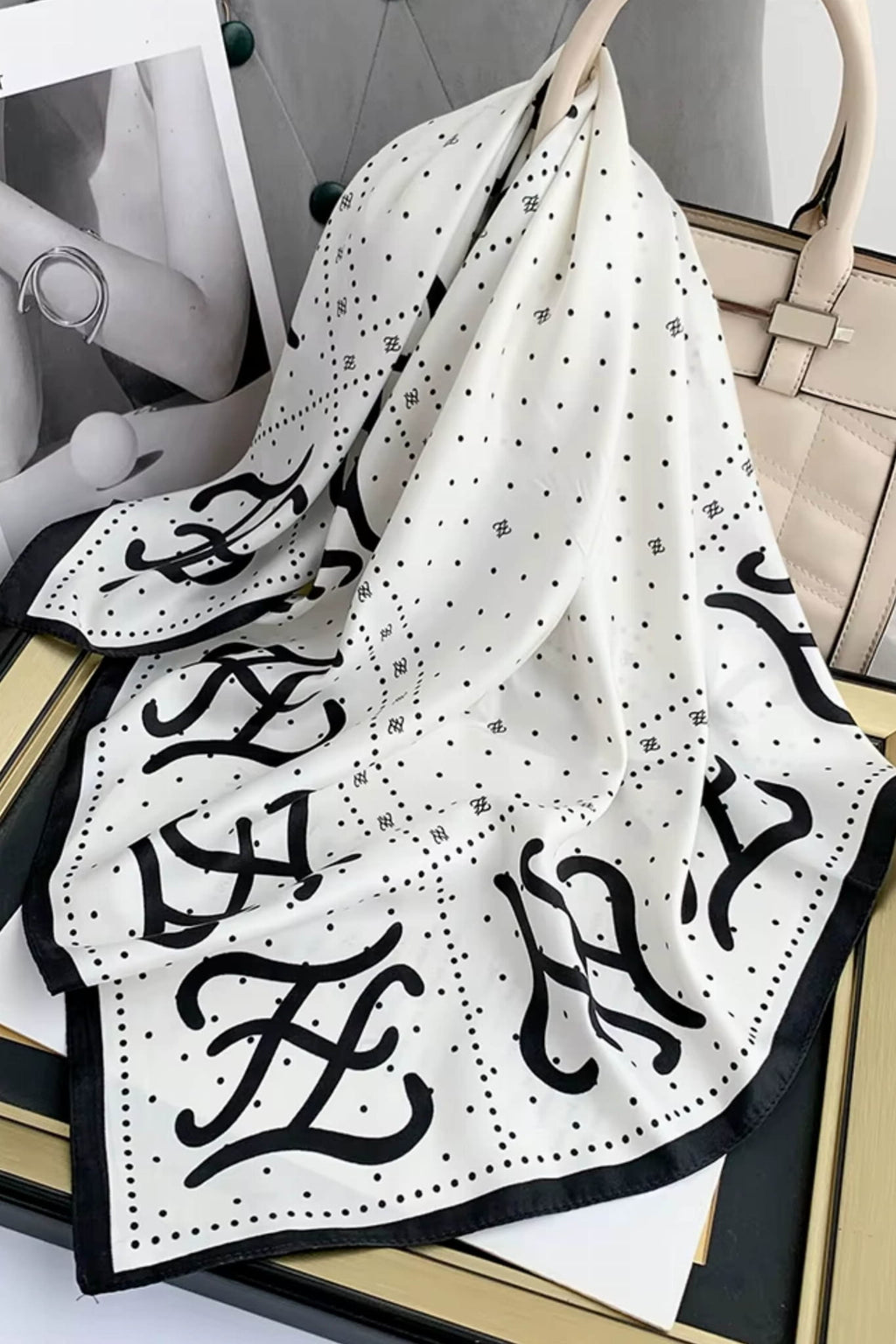 Detal apaszki z monogramem, ukazujący delikatny połysk materiału i subtelne groszki | KAMEA | Spironik.pl