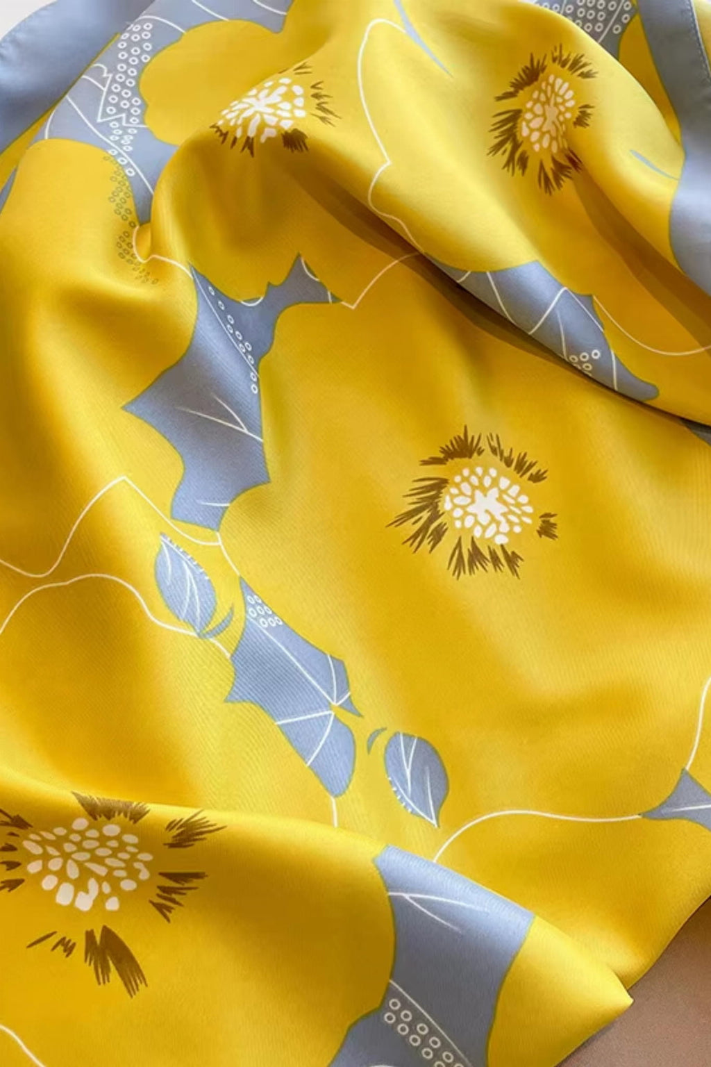 Zbliżenie na wzór kwiatowy apaszki „Letni Blask” w odcieniach żółci i szarości | KAMEA | Spironik.pl