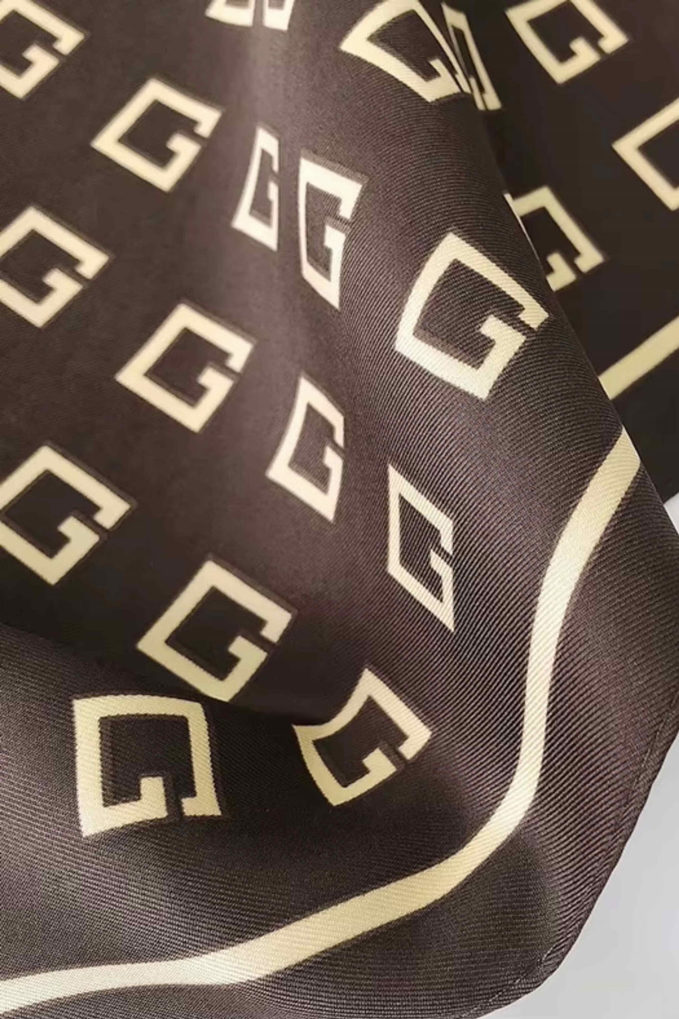 Brązowa apaszka z kratką, złożona na torebce, prezentująca styl vintage | KAMEA | Spironik.pl