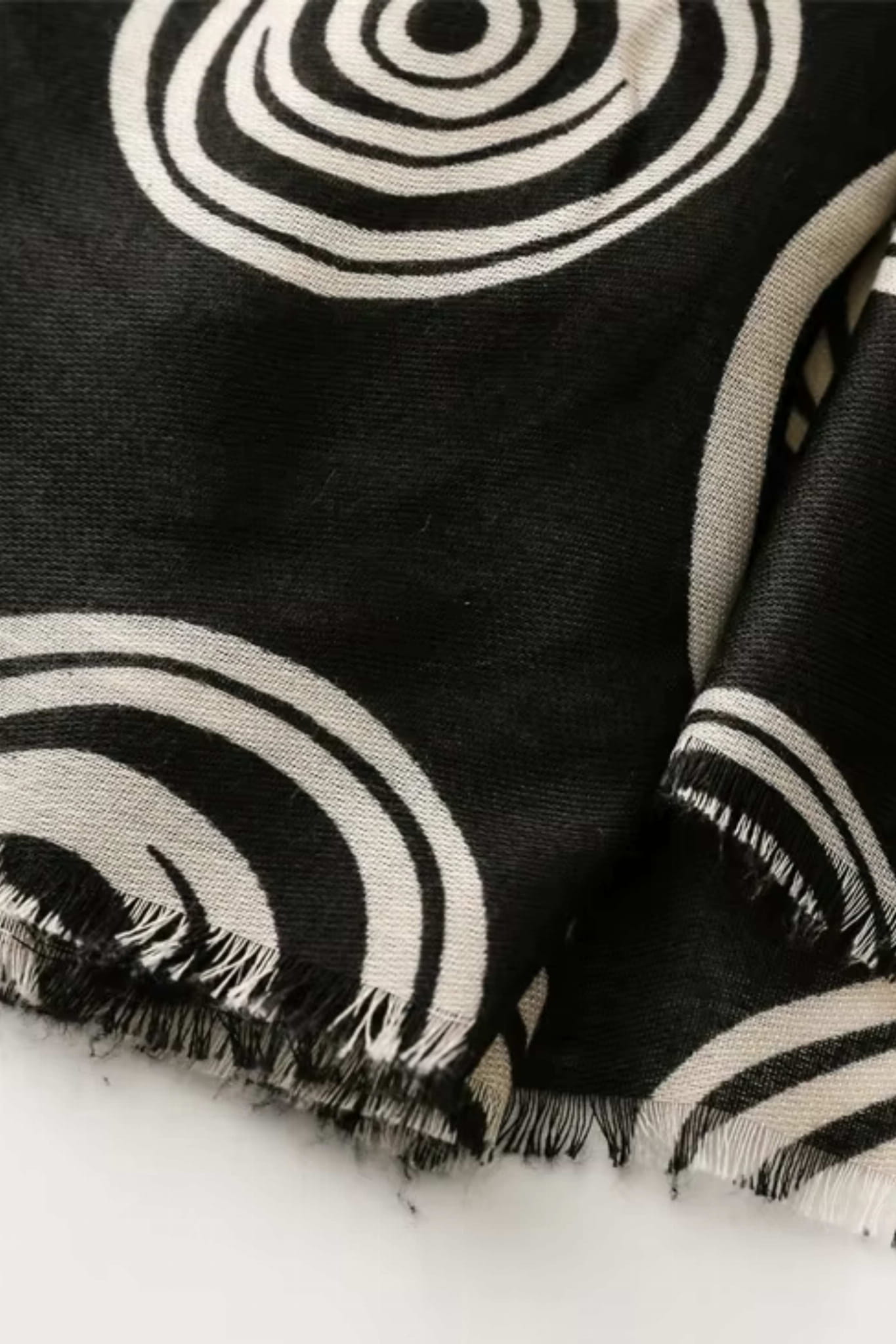 Detal geometrycznego wzoru na czarno-kremowym szalu, idealny do stylizacji casualowych | KAMEA | Spironik.pl