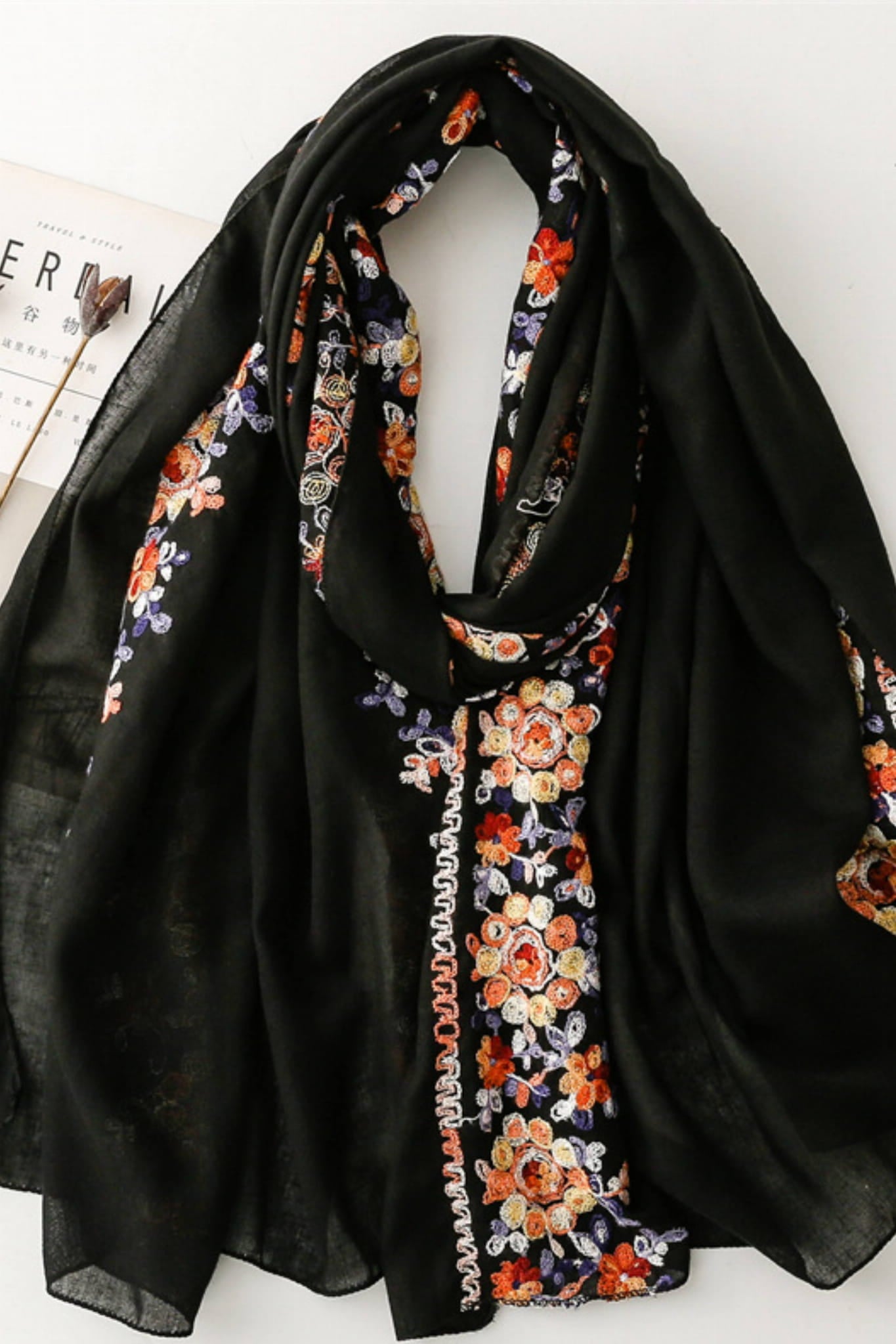 Detal haftu kwiatowego na czarnym tle, ukazujący artystyczne wykończenie szala | KAMEA | Spironik.pl