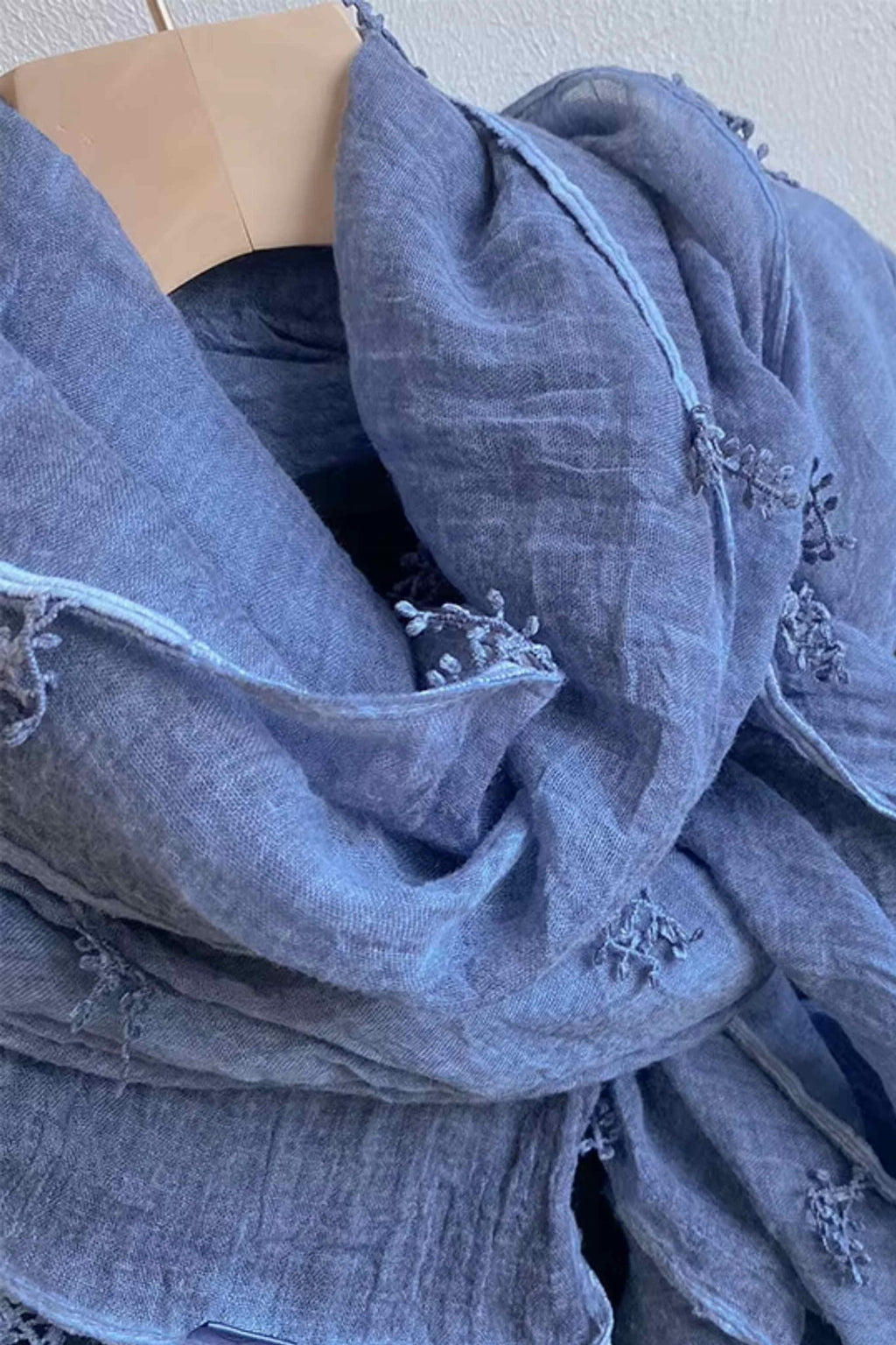 Detail výšivky ve tvaru větviček na modrém šálu, dodávající romantický charakter | KAMEA | Spironik.pl