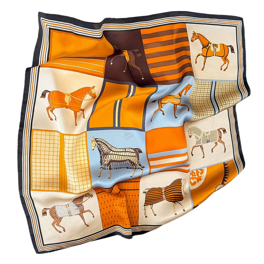 Apaszka złożona na stole, ukazująca harmonijne połączenie bursztynu, błękitu i czekoladowego brązu | KAMEA | Spironik.pl