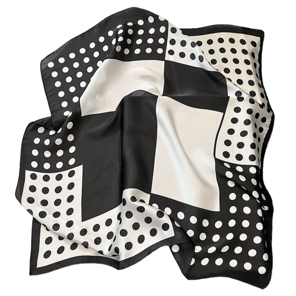 Apaszka w groszki na tle torebki, jako modny dodatek do stylizacji, dostępna w kolorze biało-czarnym | KAMEA | Spironik.pl