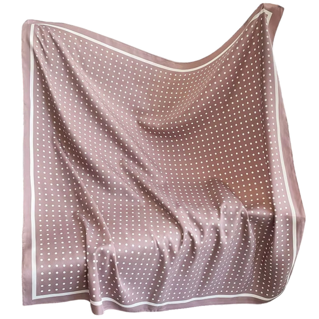 Widok apaszki w pudrowym różu z białymi groszkami, leżącej na tle jasnej powierzchni | KAMEA | Spironik.pl