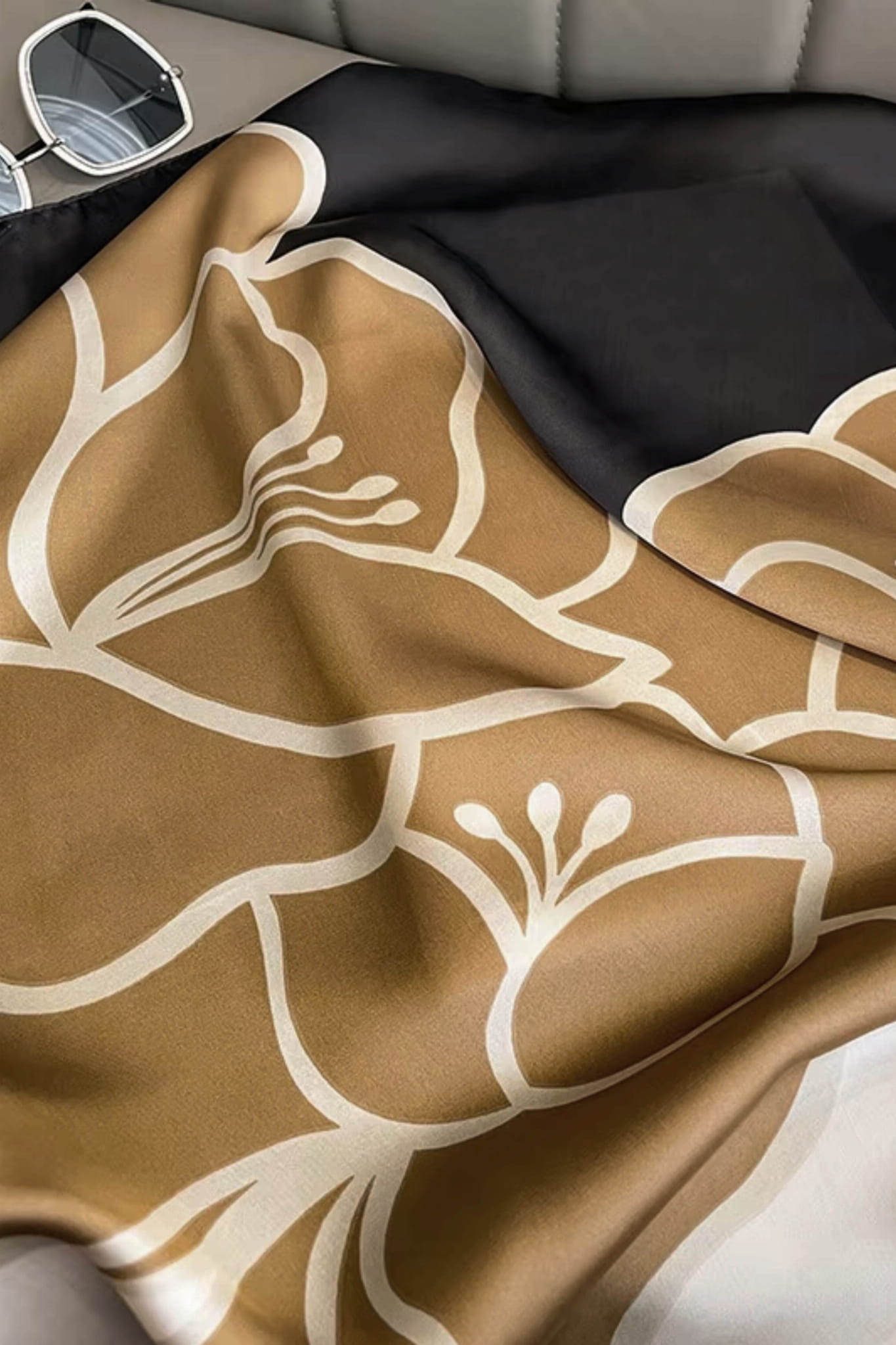 Zbliżenie na fakturę satynowego materiału apaszki, imitującego jedwab, w karmelowym wzorze | KAMEA | Spironik.pl