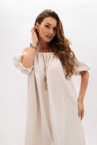 A Spanish dress with elastic waistband and pockets. Light beige color.