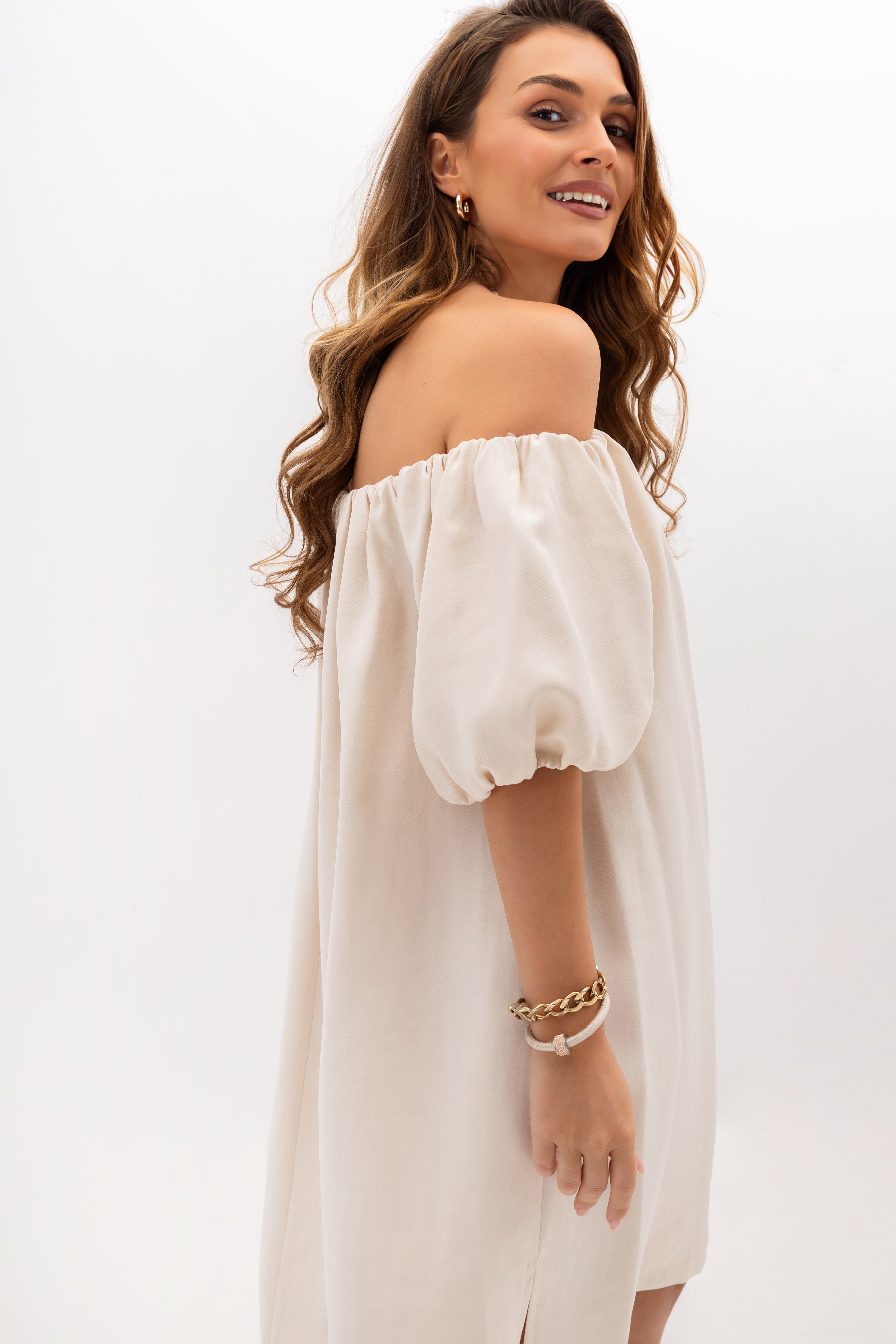 Elegant off-the-shoulder dress with puff sleeves and pockets in light beige — side view showing the effect of elasticated sleeves and loose fit | Bastet | Spironik.pl