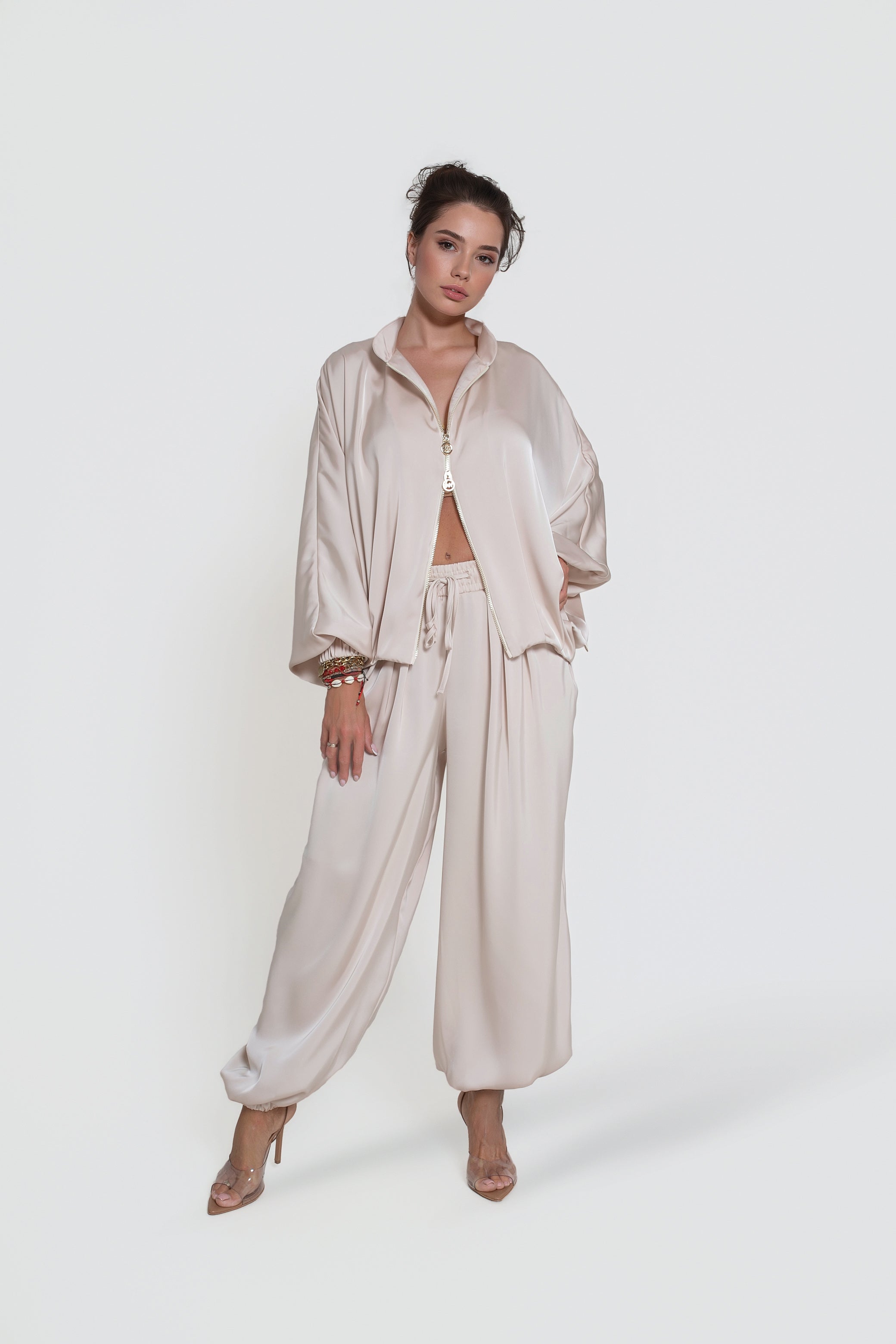 Beżowe spodnie satynowe SAVA z gumką w pasie i stylowym bluzowaniem nogawek do codziennych stylizacji | BastetStore | Spironik.pl