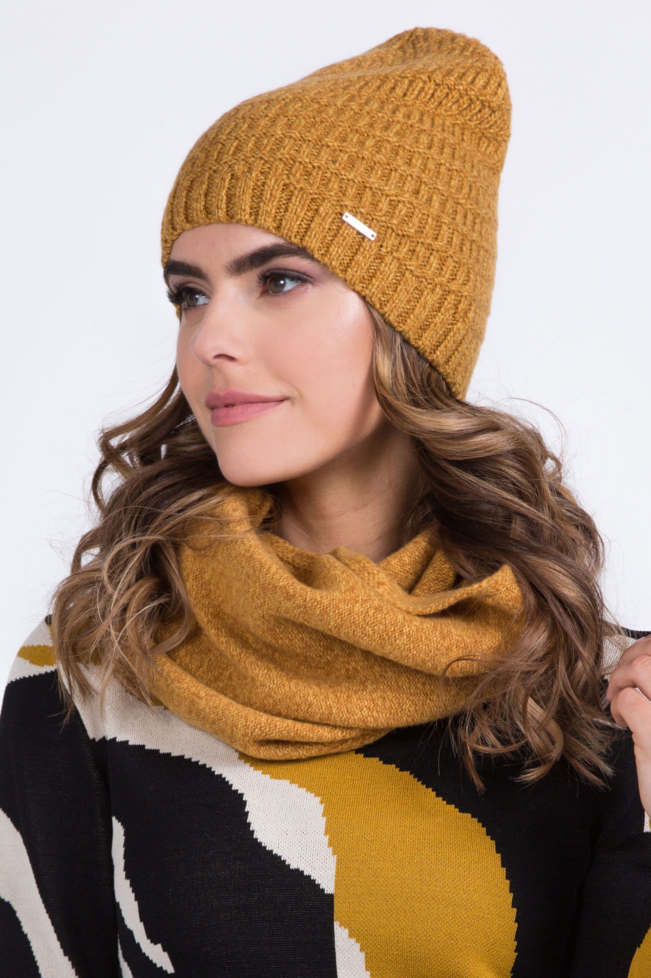 Detal czapki NEFRA w musztardowym kolorze, z delikatnym ściągaczem i ciekawym splotem materiału | KAMEA | Spironik.pl