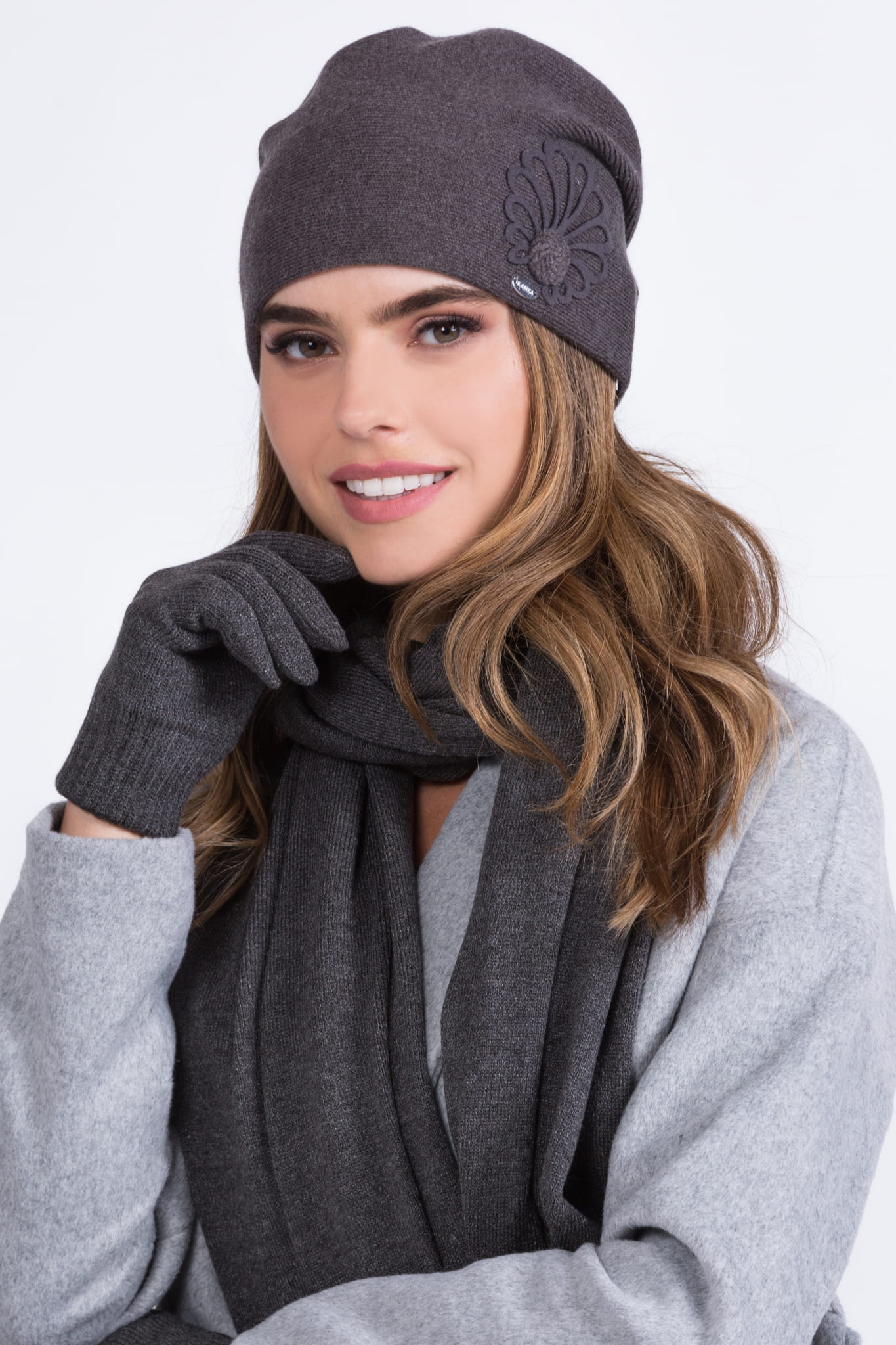 Detal czapki MALWA z flauszową aplikacją i srebrnym znaczkiem, zapewniająca komfort cieplny w chłodne dni | KAMEA | Spironik.pl