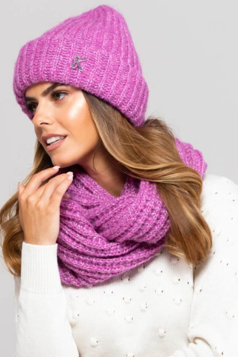 Detal czapki GRENADA w kolorze różowym, z połyskującą blaszką w formie litery "K" na boku | KAMEA | Spironik.pl