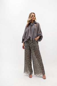 Loose-fitting lace trousers with pockets and an elastic waistband. Color: Stonewashed Gray