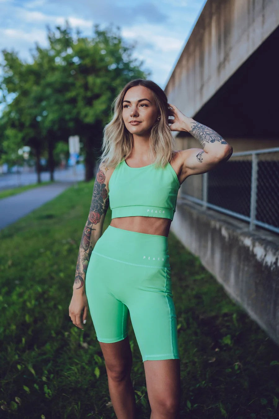 Stylizacja sportowa z zielonymi szortami – ECO moda, minimalizm i kobiecy look.