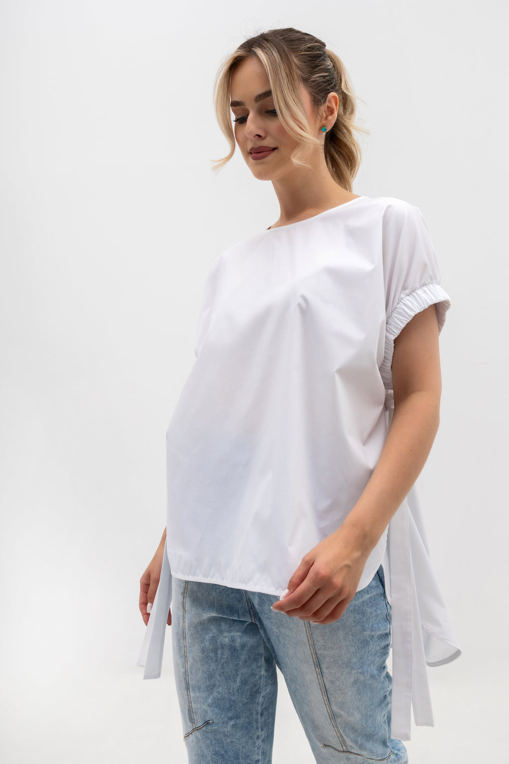 Asymetryczna bluzka oversize w kolorze białym z dekoracyjnymi wiązaniami po bokach | Bastet | Spironik.pl