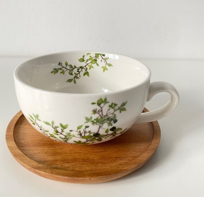Filiżanka z przykrywką w użyciu, na stole z widokiem na akcesoria kuchenne | EasyLife | Spironik.pl