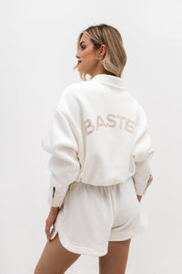 Bomber jacket with logo detailing - stand-up collar, buttons, and lining. Color: Ecru (gold lettering)