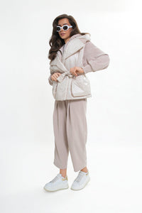 Women's quilted vest with a hood and belt. Light beige color.